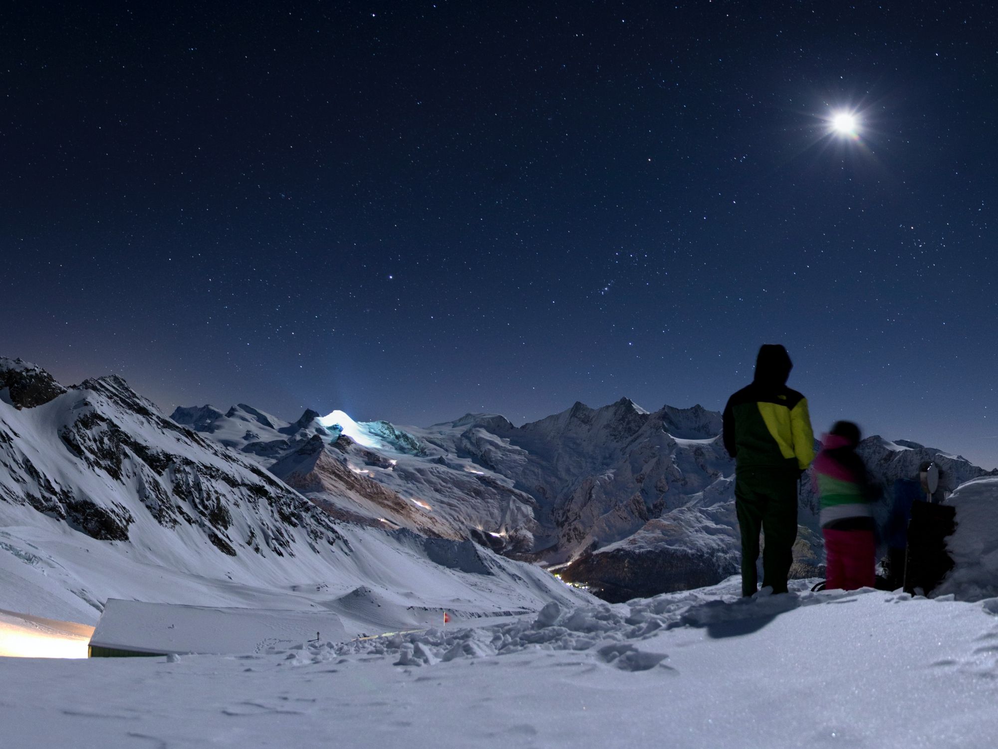 Saas Fee Nachtschlitteln Hohsaas bei Nacht mit schneebedeckten Bergen