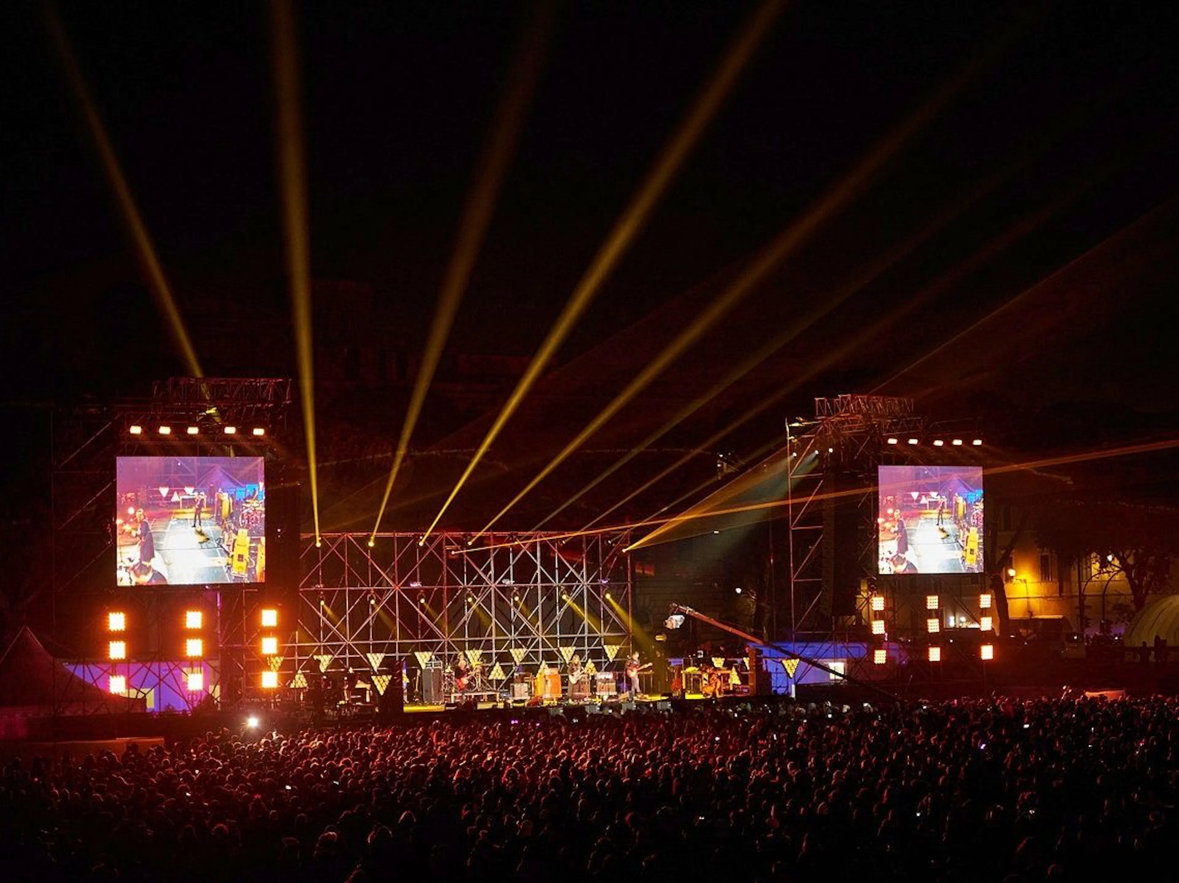 คอนเสิร์ต: ผู้คนมากมายที่งานแสดงสดพร้อมไฟสวยๆ และเวทีในตอนกลางคืน.