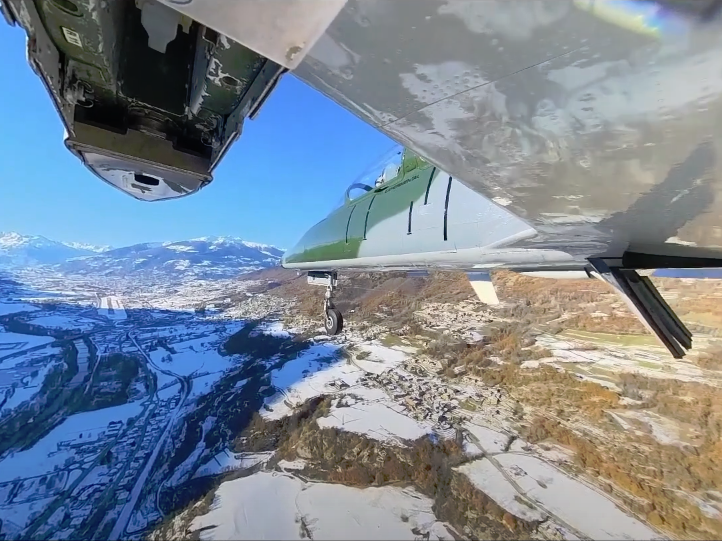 Aermacchi S.211 en vol au-dessus des montagnes avec des paysages enneigés et un ciel dégagé