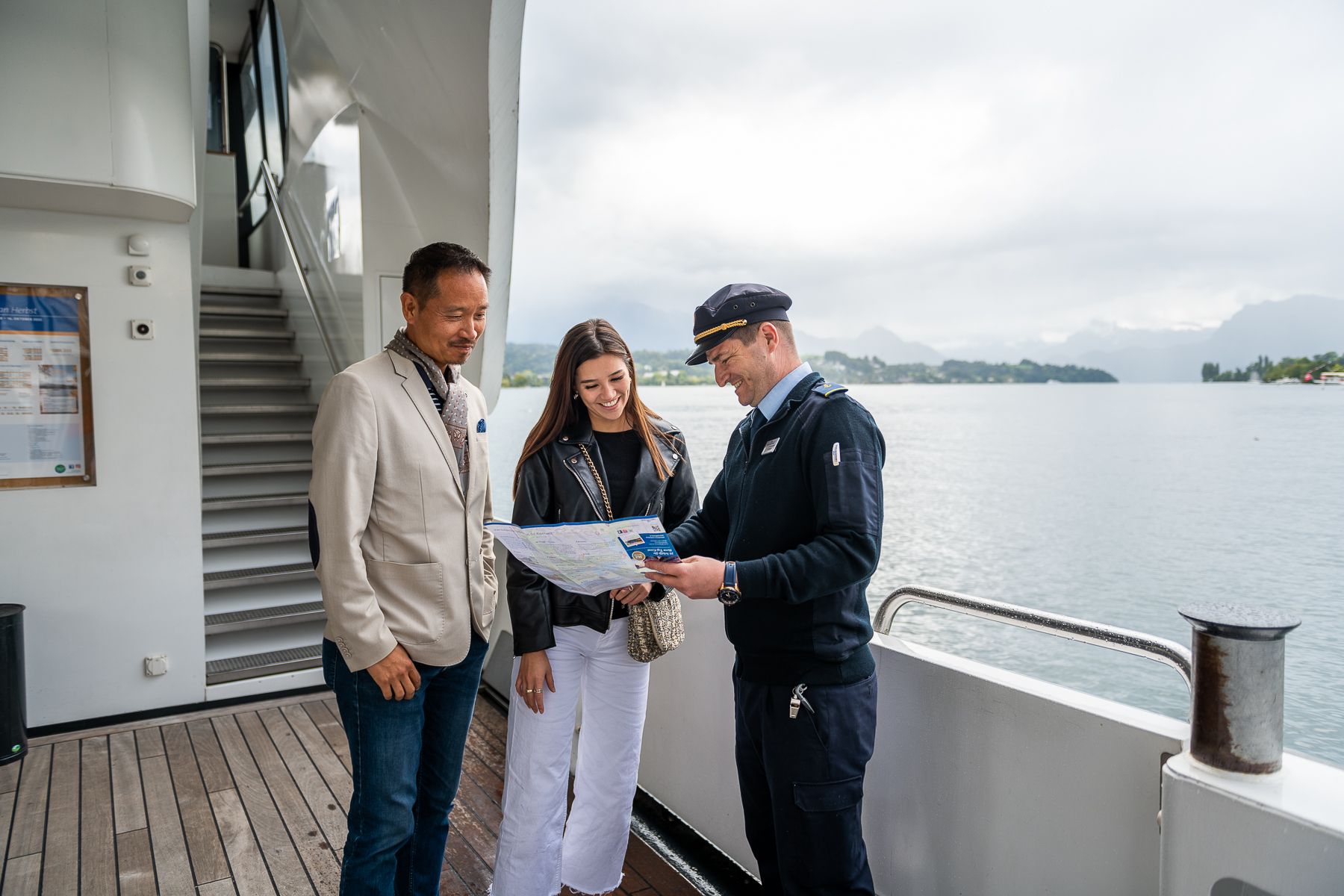 Panoramayacht Vierwaldstättersee: bemanning legt de route uit, genieten van de omgeving met vrienden.