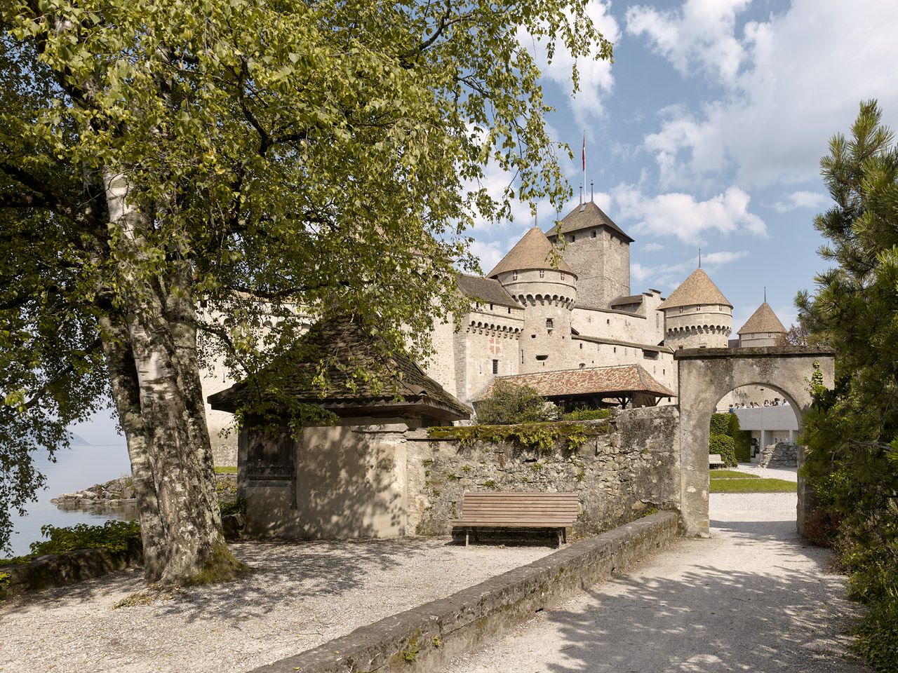 Chateau Chillon di Danau Geneva dengan taman dan bangku