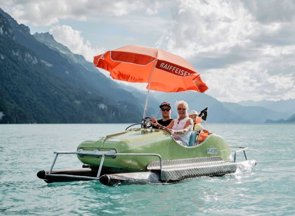 Pedalo Miete am Brienzersee mit Sonnenschirm und Fahrern.