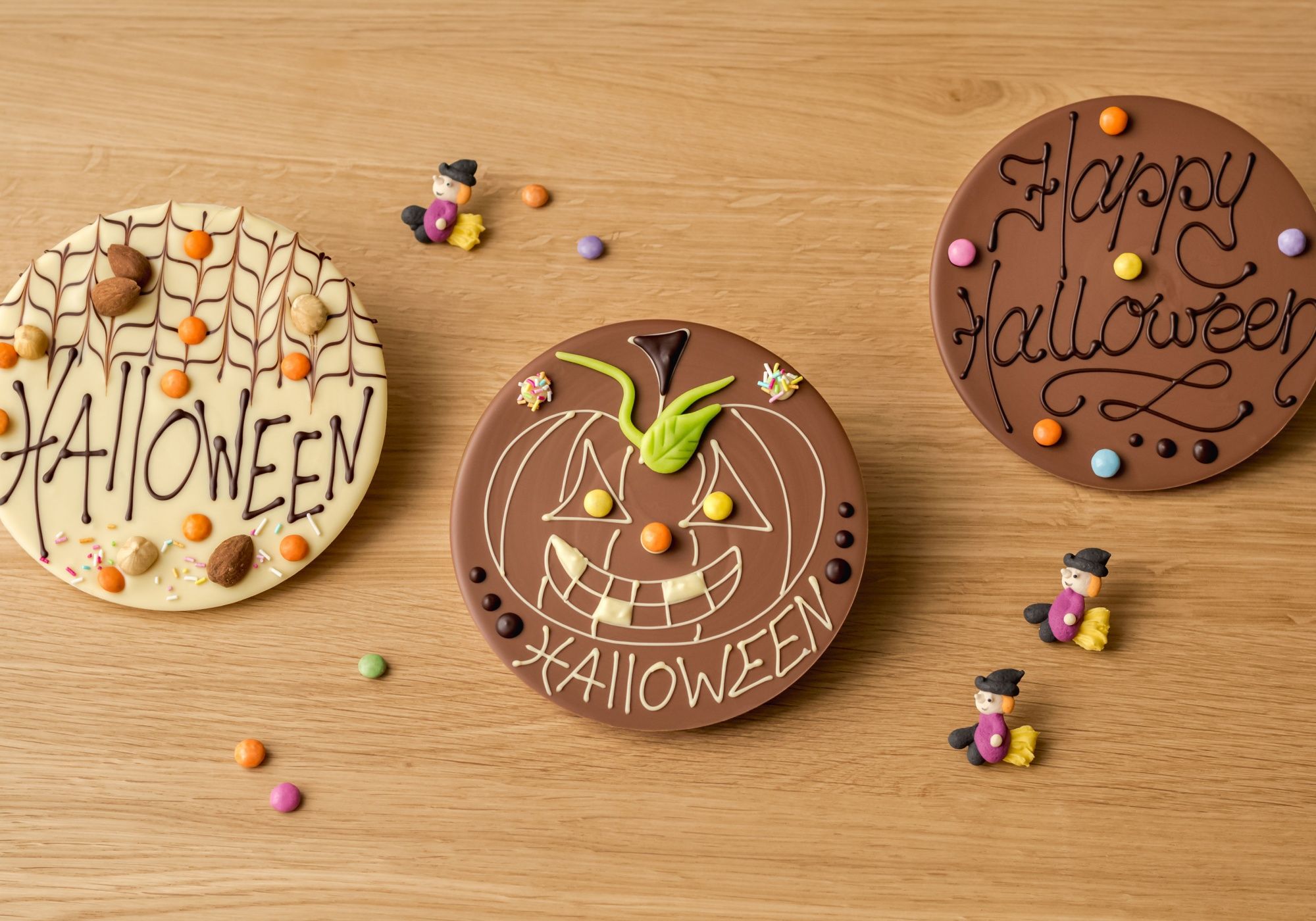 Каiller Хэллоуин: яркие шоколадные торты с тематикой Хэллоуина и конфетами на деревянной поверхности