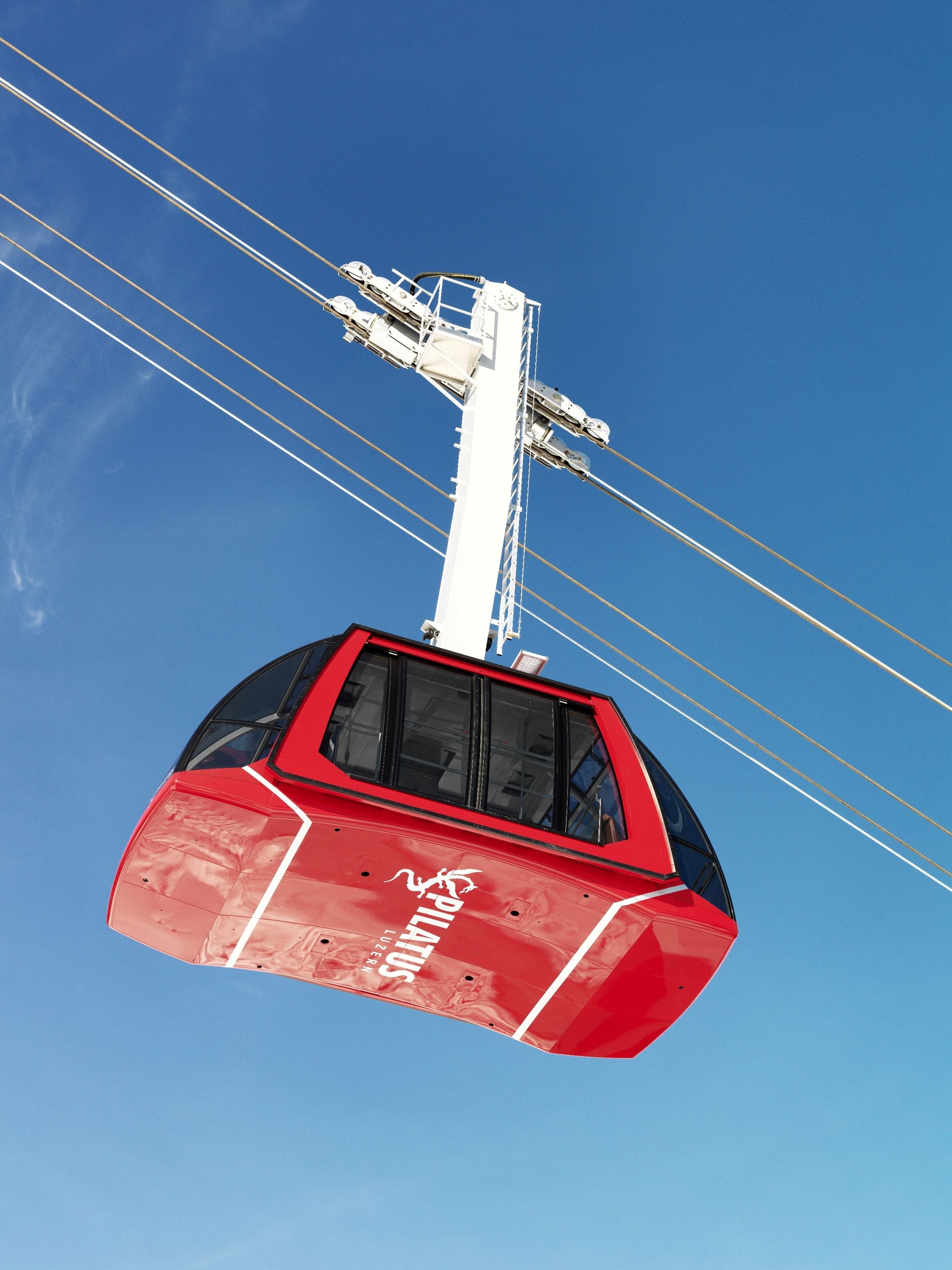 Pilatus Dragon Ride: Seilbahn mit Aussicht auf den blauen Himmel und die umliegenden Berge.