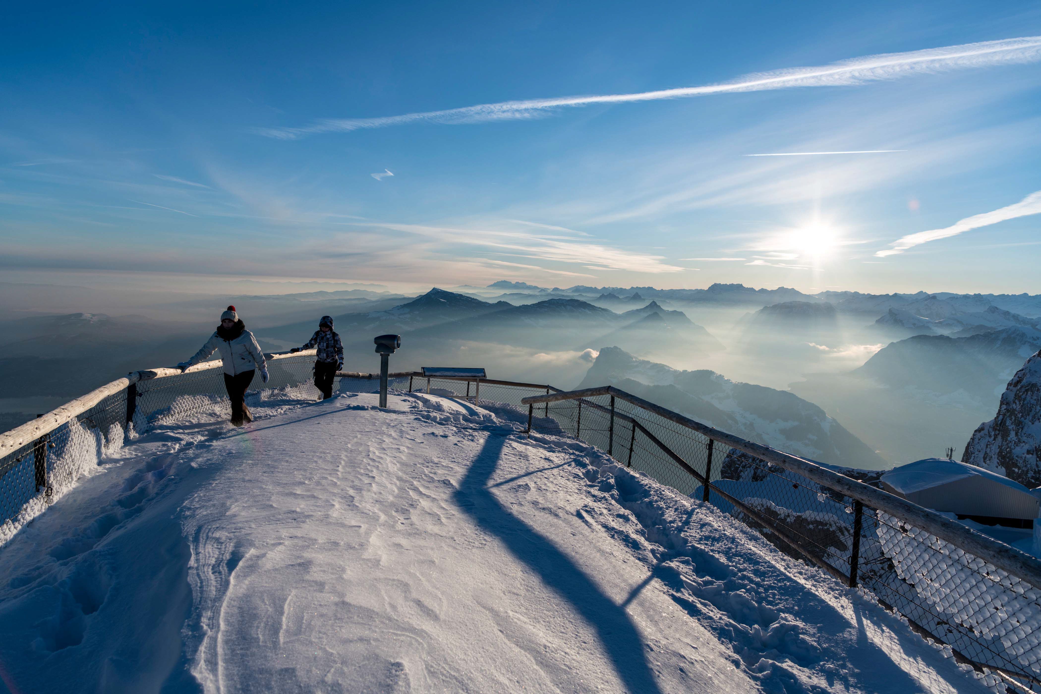 Pilatus: Zwei Personen spazieren durch wunderschönen Schnee und genießen die Aussicht.