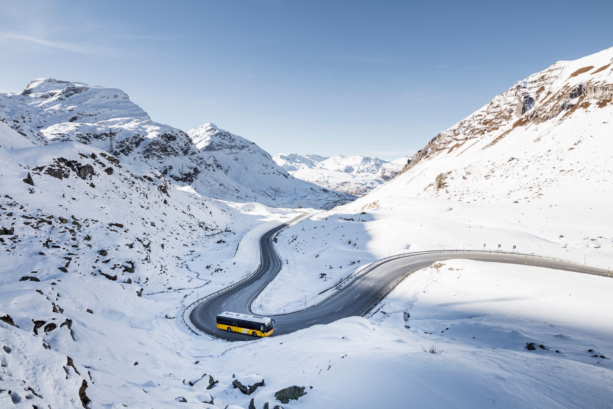 PostAuto Palm Express: Erlebe die winterliche Schönheit des Oberengadins mit schneebedeckten Bergen.