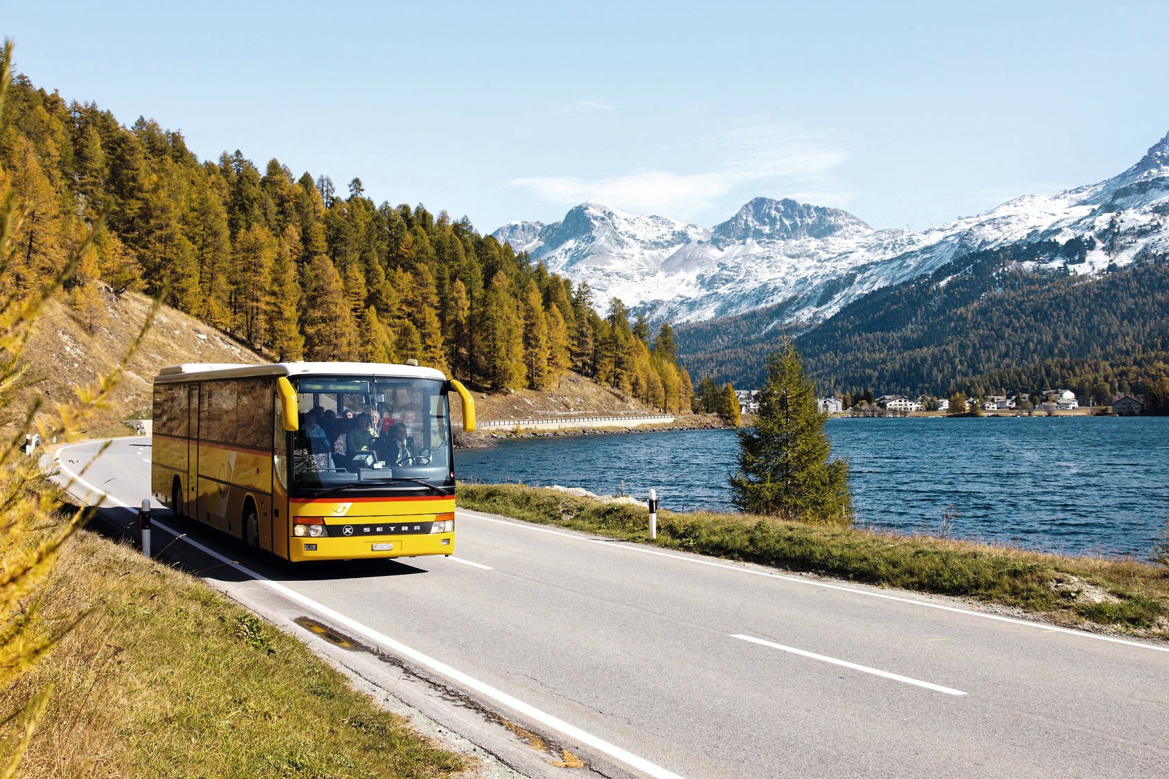 PostAuto Palm Express au Silsersee dans l'Oberengadin avec montagnes et nature.