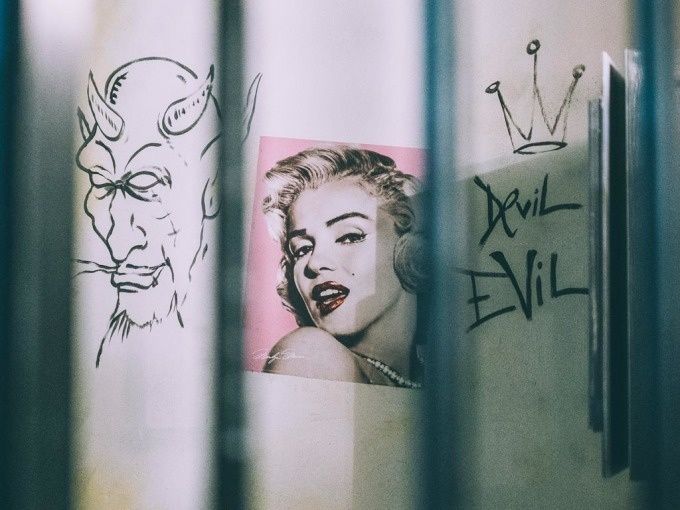Nástěnná malba s ďáblem a Marilyn Monroeovou v vězeňské cele