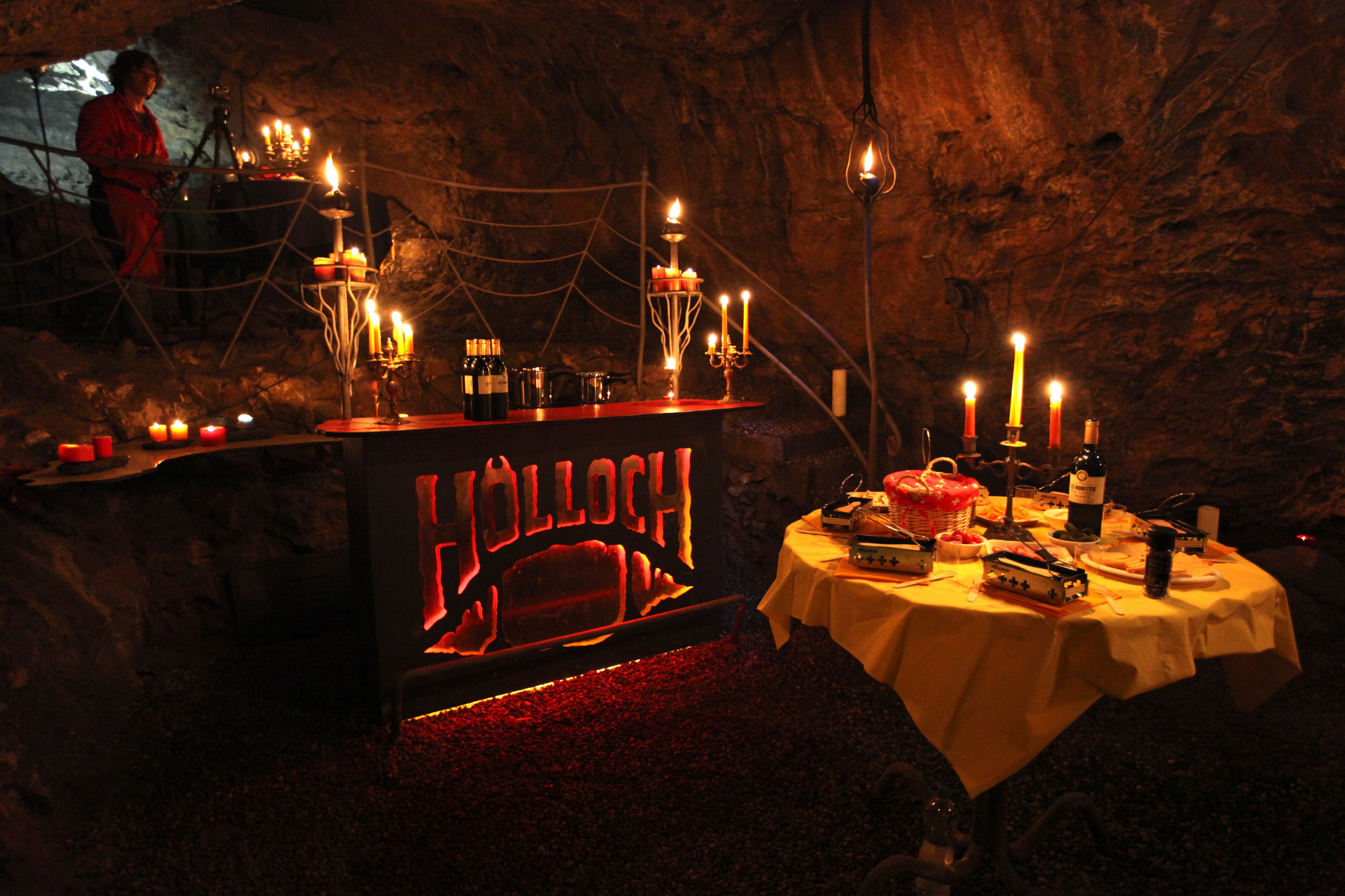 Raclette en la cueva con velas, mesa y decoración.