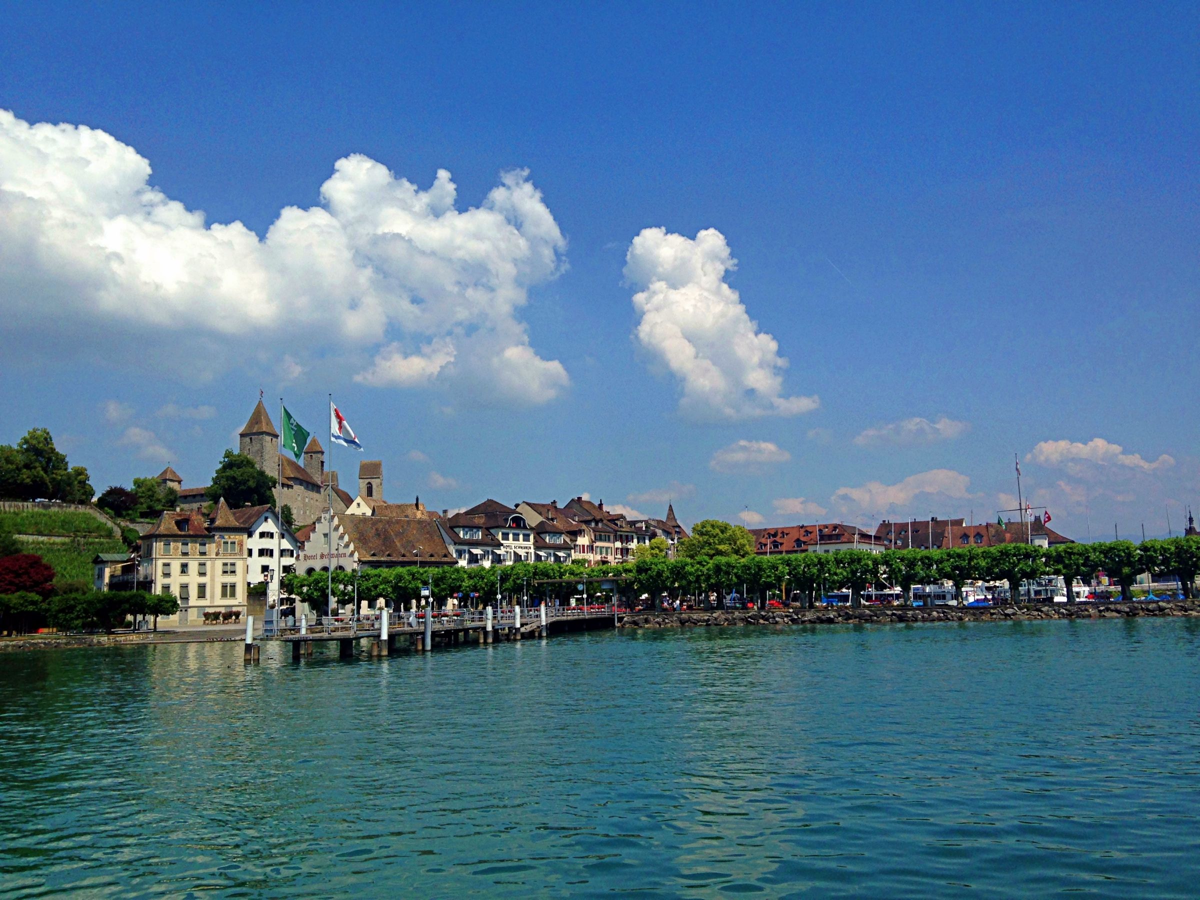 Rapperswil com a paisagem do lago no Lago de Constança, céu azul e nuvens.