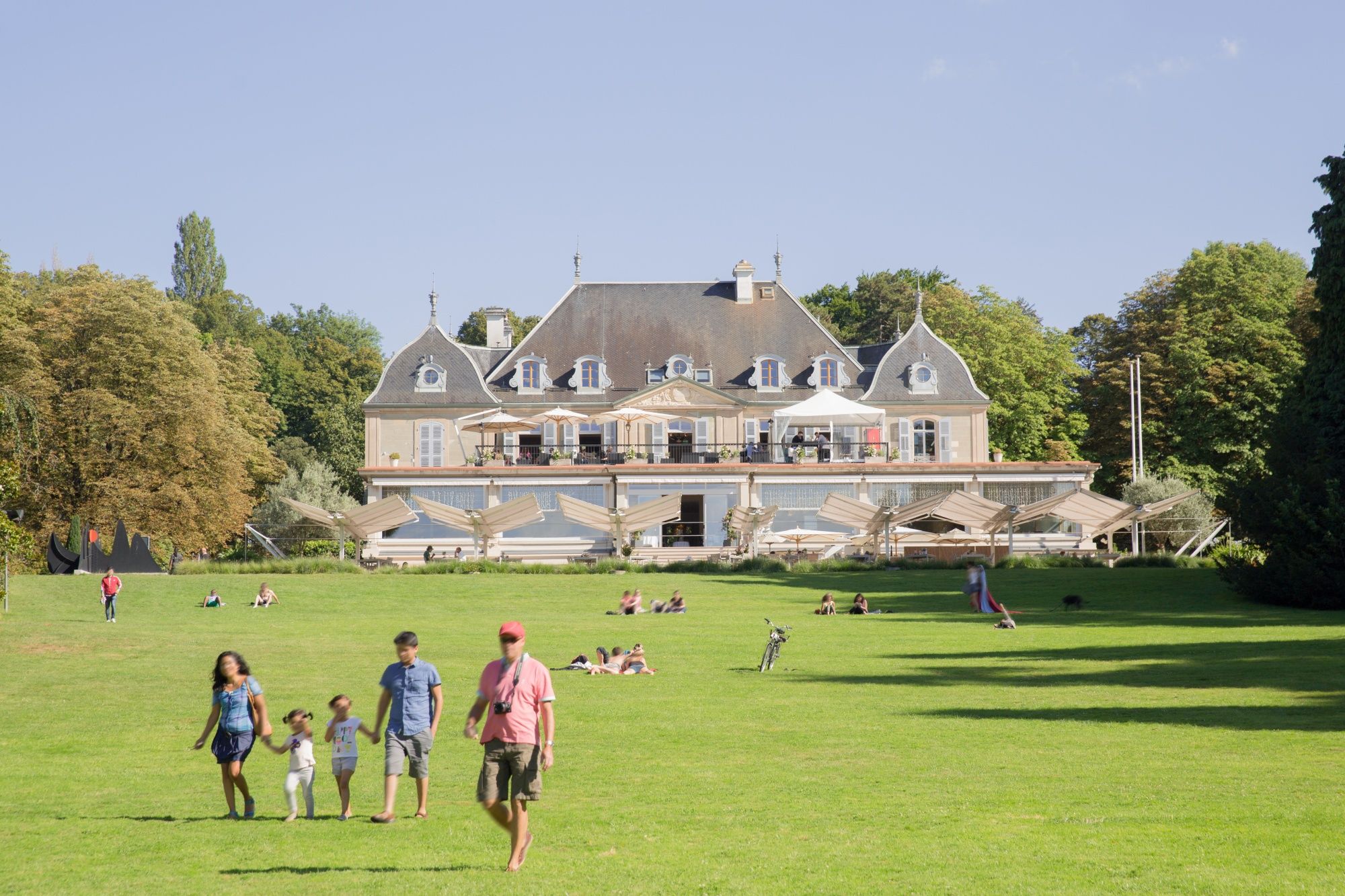 Hotel Parc des Eaux-Vives con ospiti nel parco, passeggiata sull'erba.
