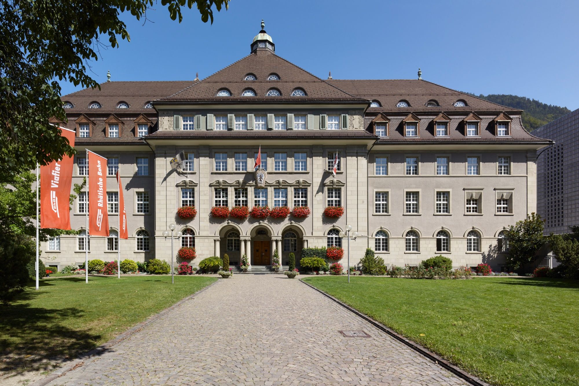 Rhetoriskbane: Historisk bygning i Chur med planter og grønt omgivelser, ideelt til afslapning.