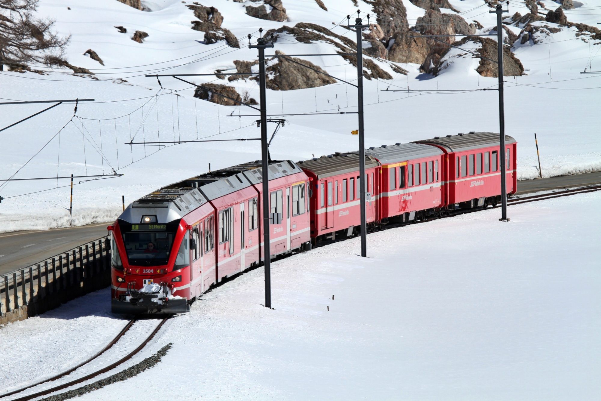 Ferrovia Retica in inverno, montagne innevate e paesaggi idilliaci nelle Alpi.