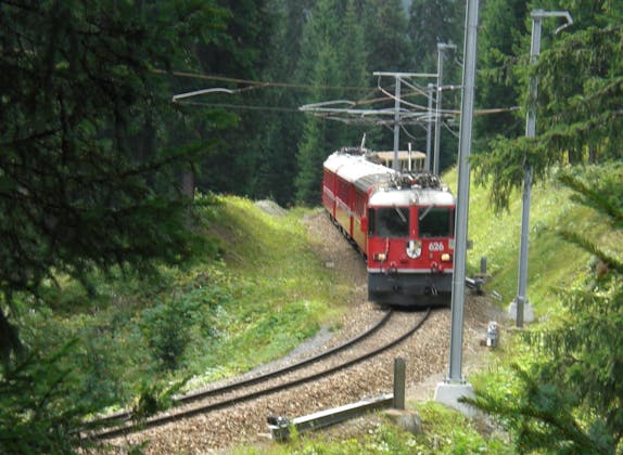 Kereta Rhaetische: Rasai pengalaman kereta api Arosa di landskap hutan hijau di Switzerland.