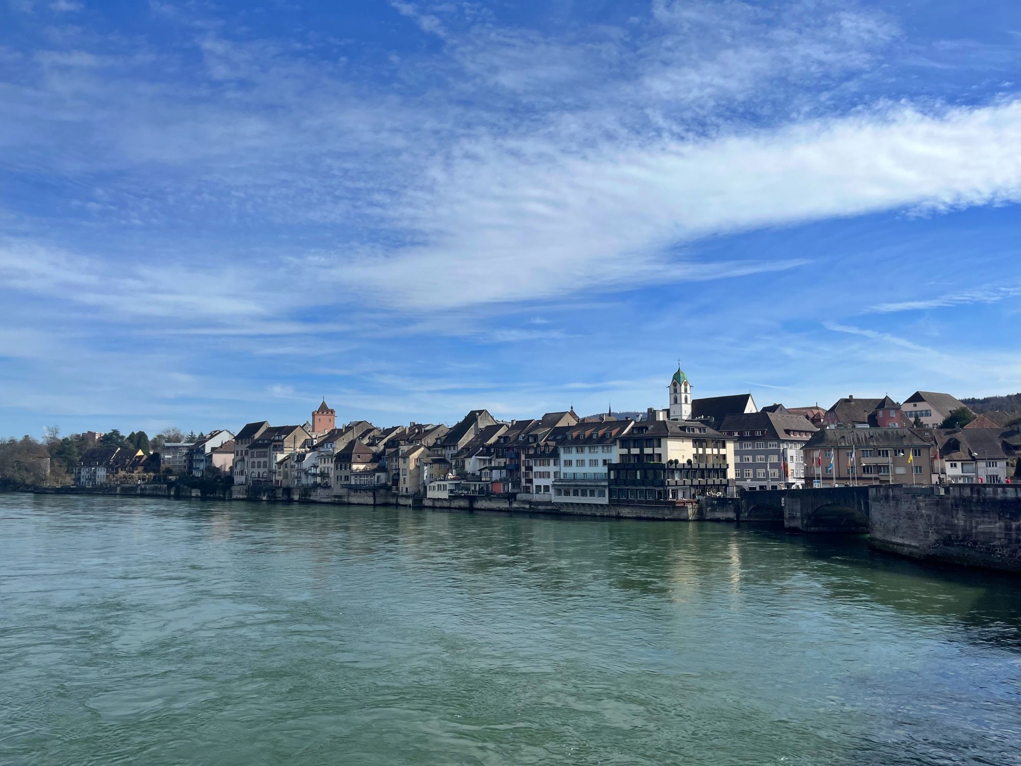 라이프펠덴: 그림 같은 강변 산책로, 라인 강의 역사적인 건물들과 파란 하늘.