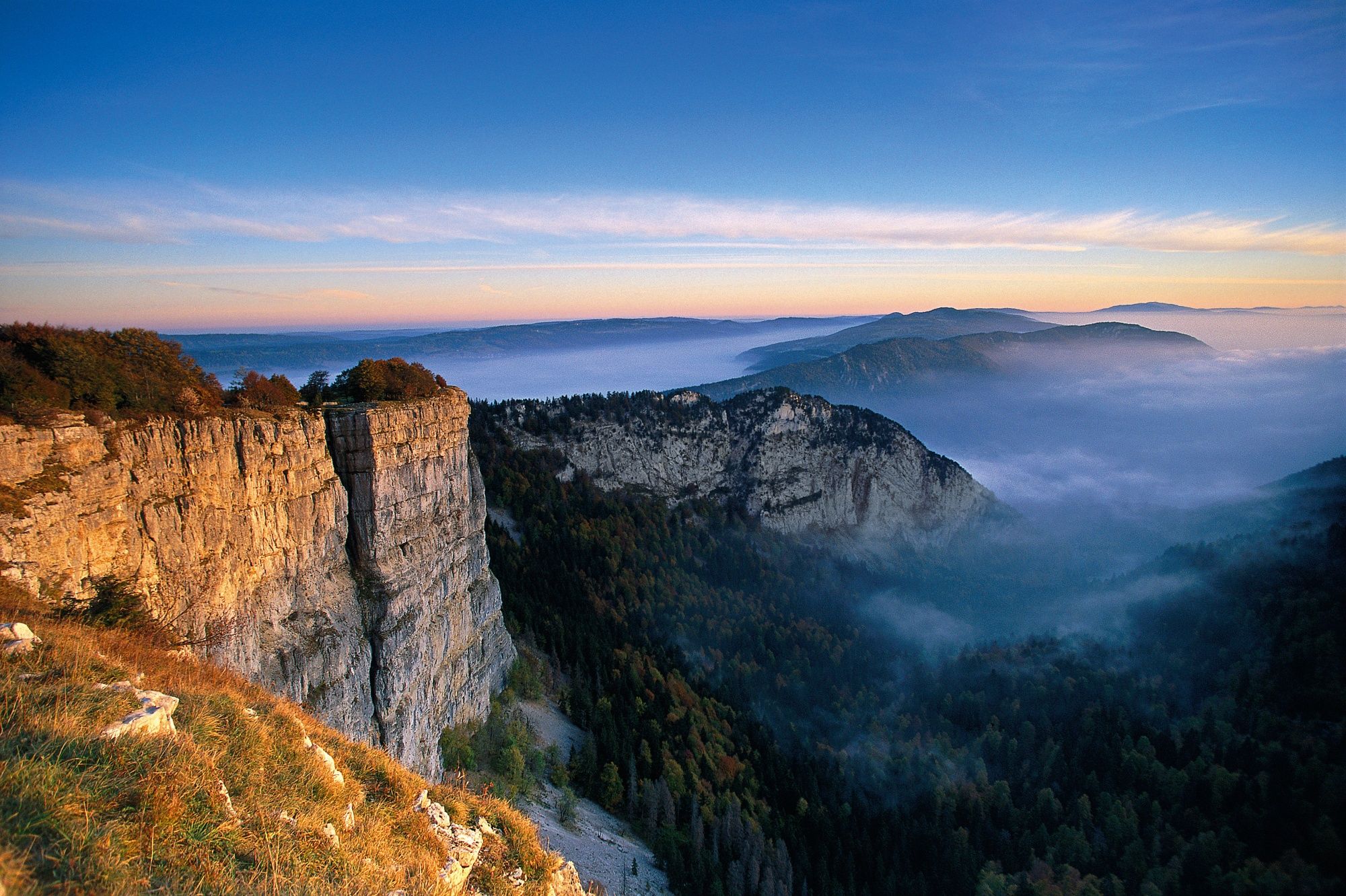 Wanderung im Jura mit Blick auf die bewaldete Landschaft und Fjell