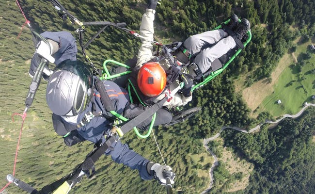 Volo in tandem con parapendio in sedia a rotelle con una vista spettacolare sulle montagne nella natura.