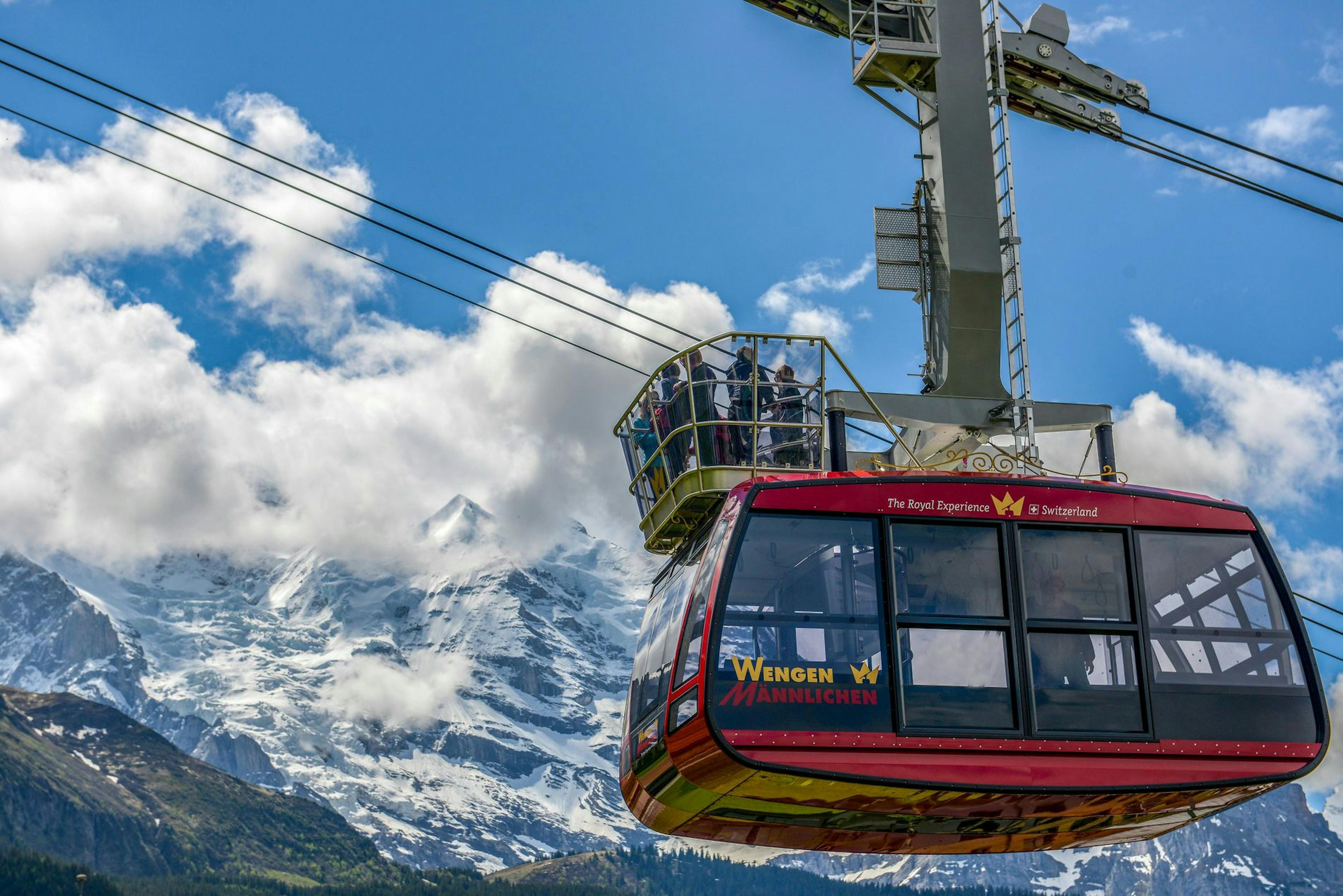 The Wengen-Männlichen cable car transports passengers with a view of the mountains.