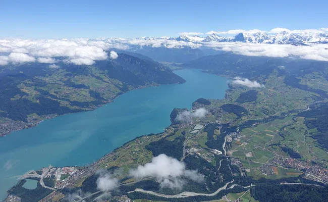 Thunsee sedd ovanifrån med moln och berg.
