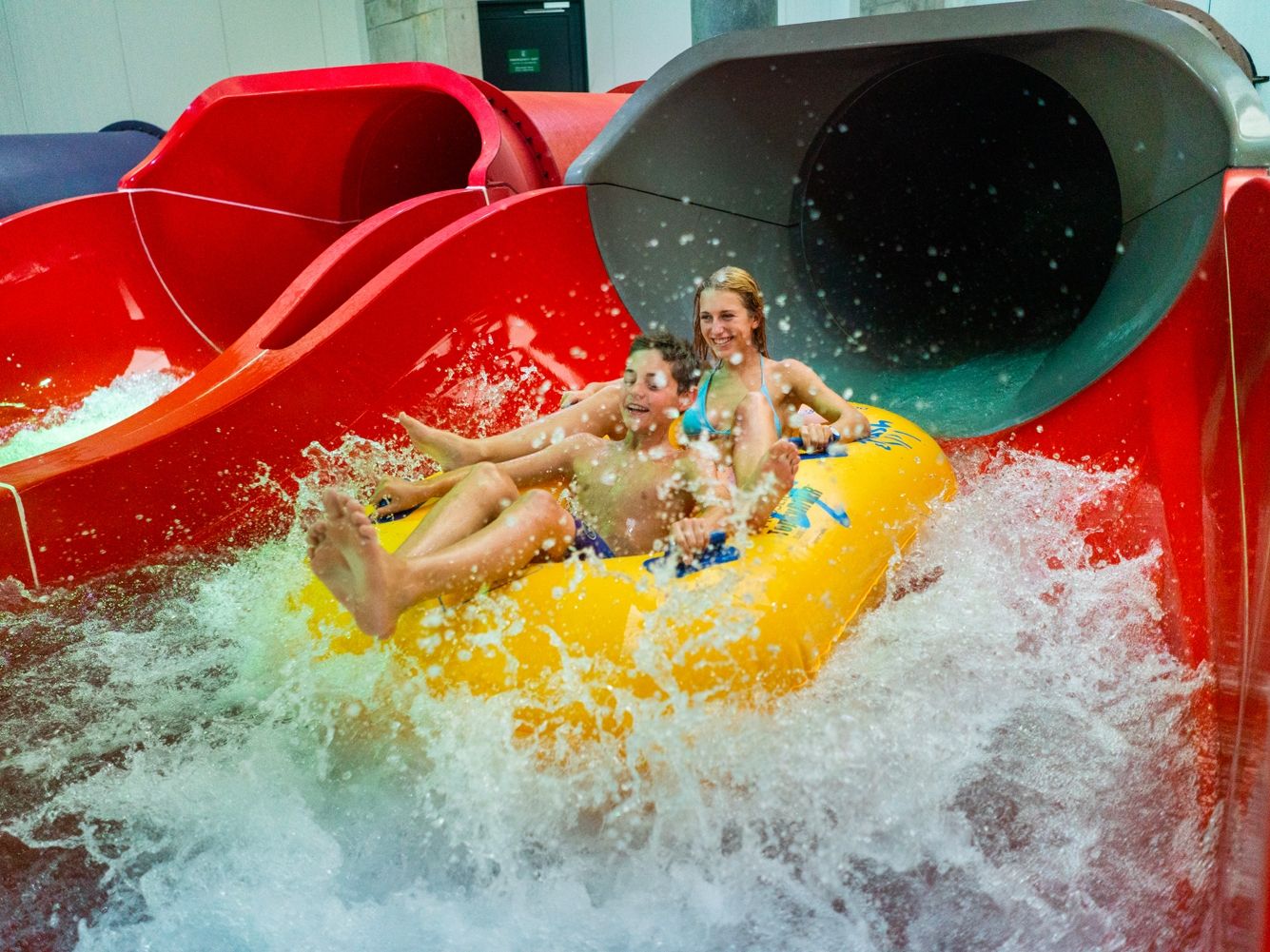 Toboggan aquatique dans le Ruthsche Reifen Splash et Spa, enfants sur des pneus, éclaboussures d'eau.