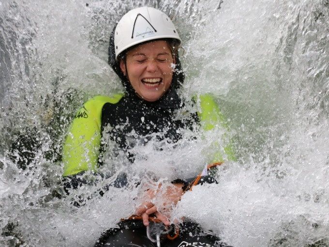 Deslizamiento Húmedo Canyoning Pro Val Grande con agua salpicando y participantes