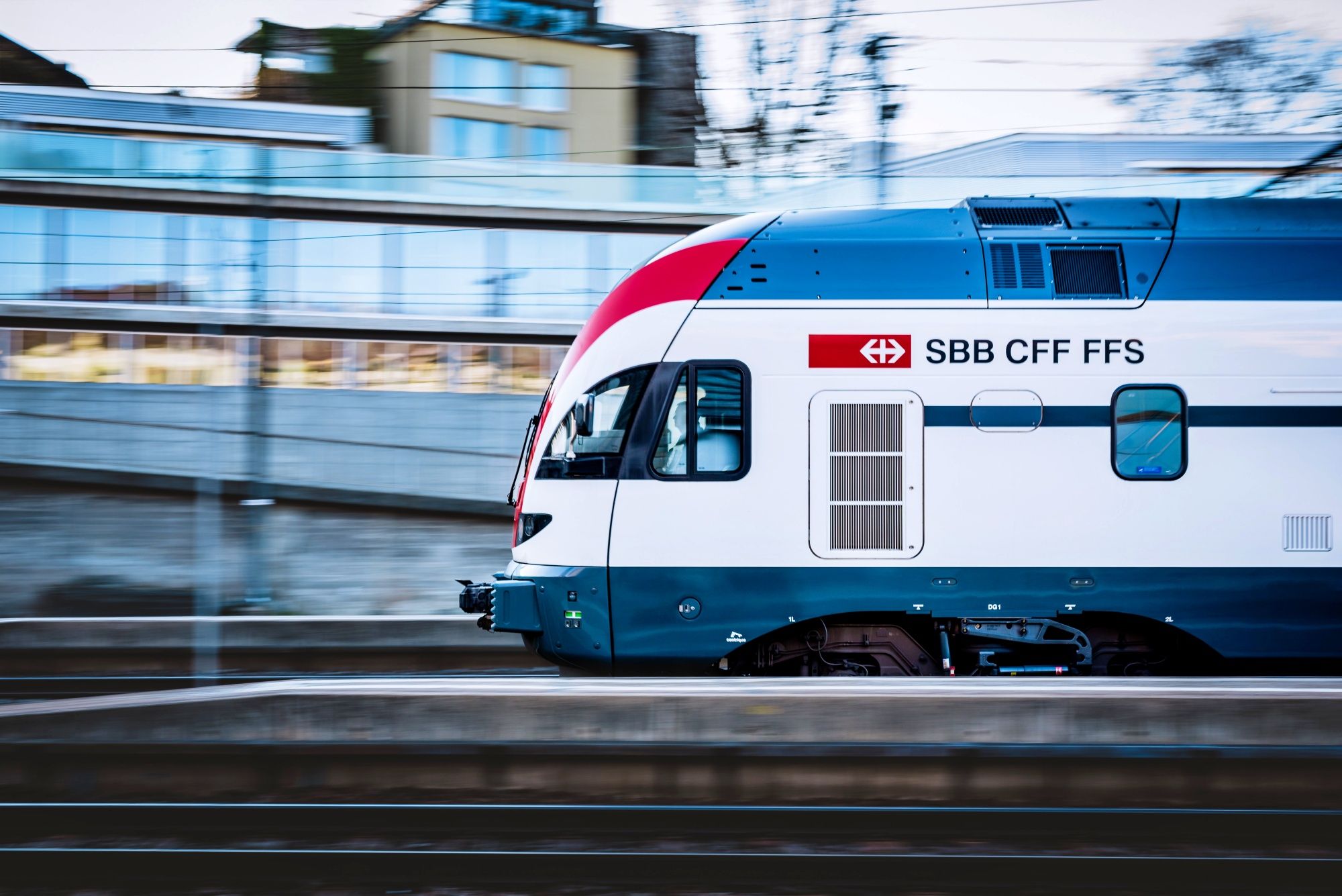 SBB Trein: moderne trein in Zwitserland passeert het station, snel en comfortabel voor reizigers.