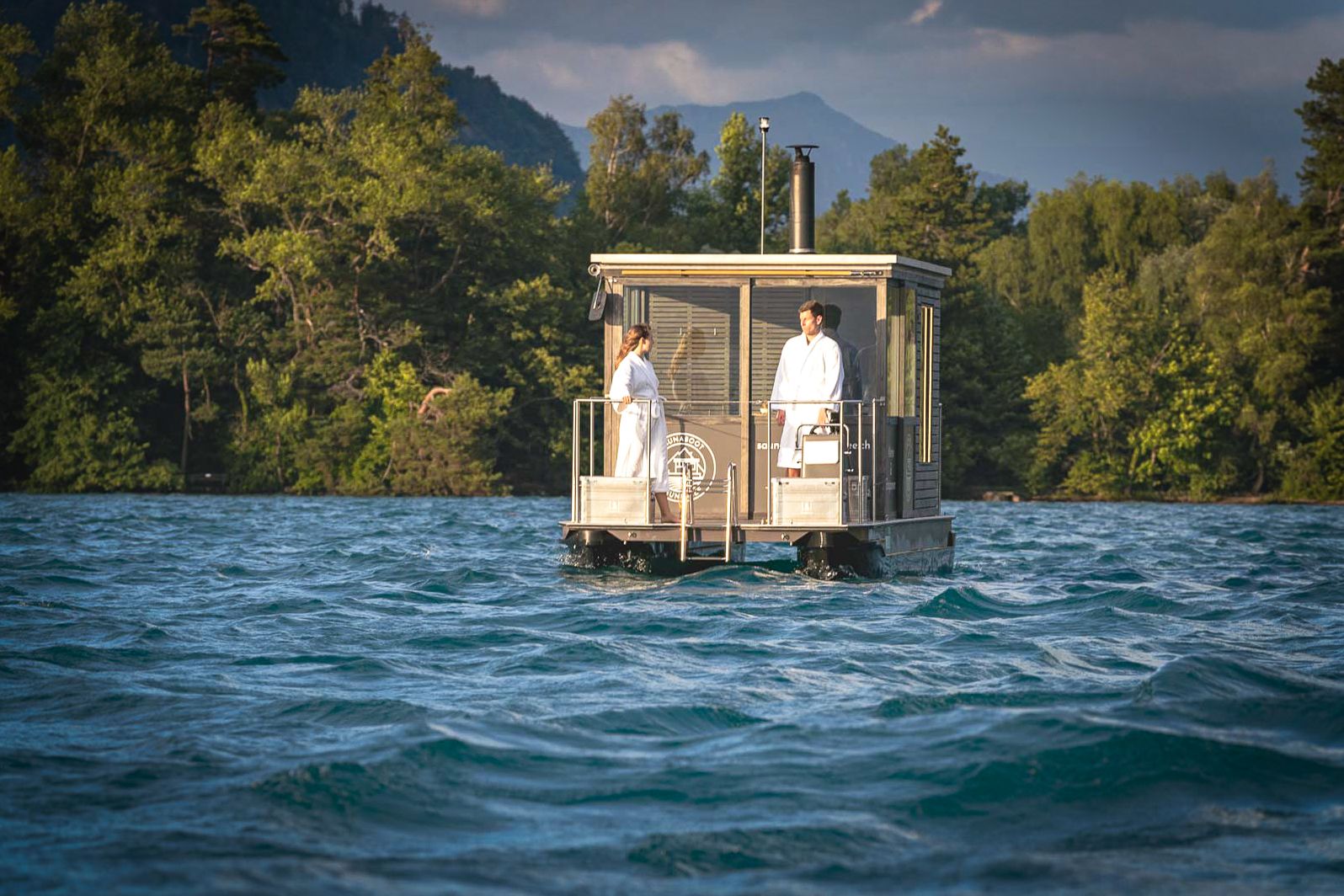 Băi cu saună pe apă cu vedere la munți și împrejurimi, activitate de wellness relaxantă.