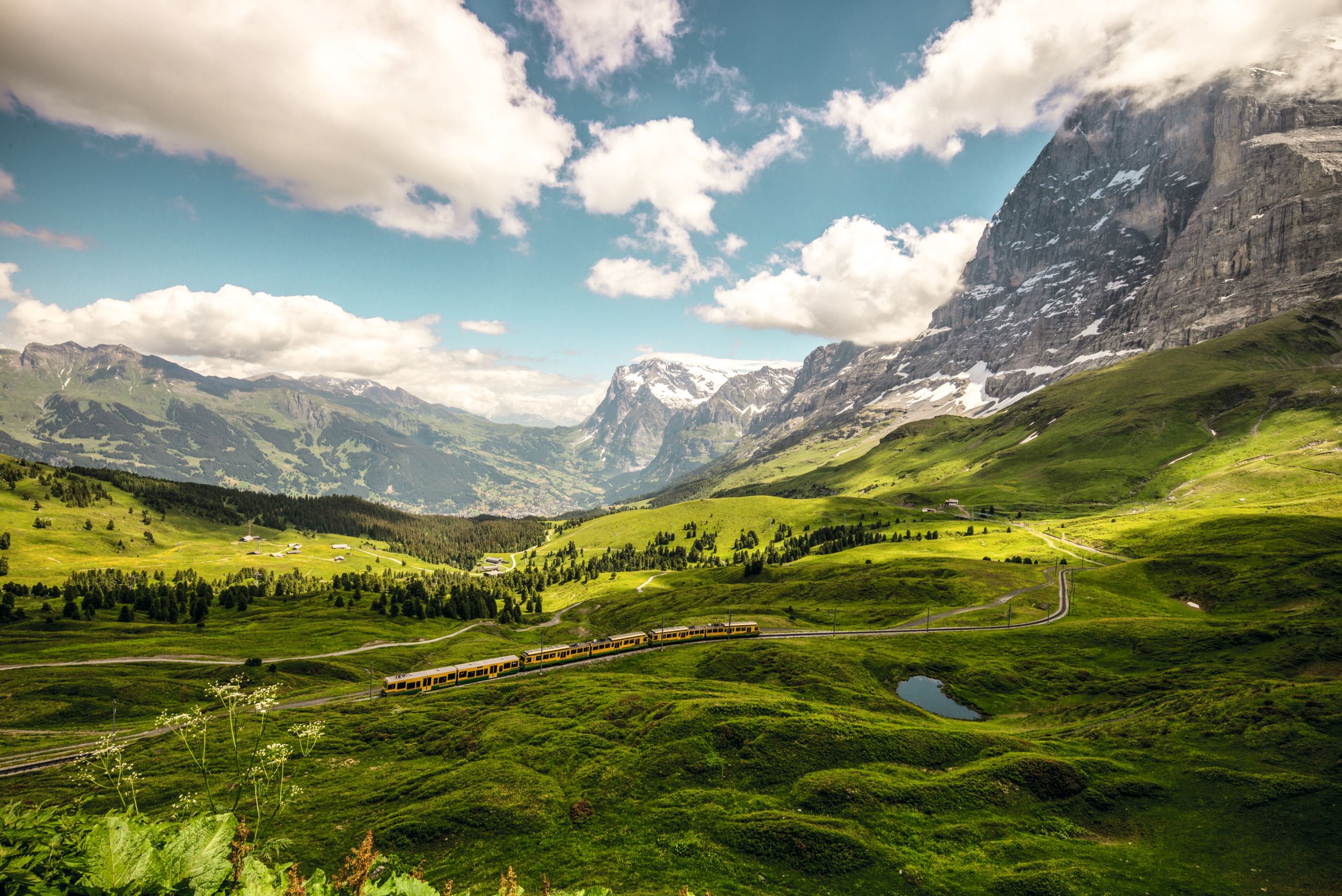 Lauterbrunnen Kleine Scheidegg: picturesque landscape with mountains, green meadows and train ride.