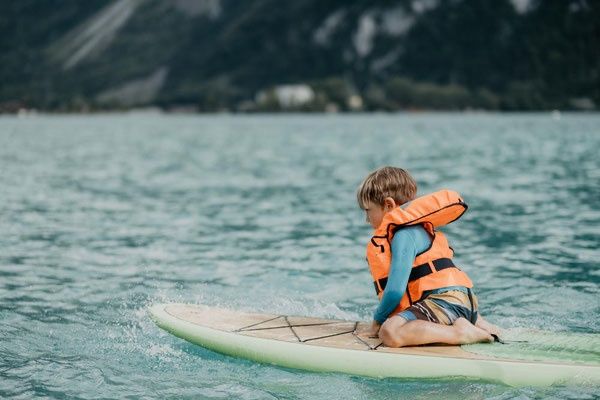 Stand-up paddle Brienz. Venlig paddler på søen med redningsvest.