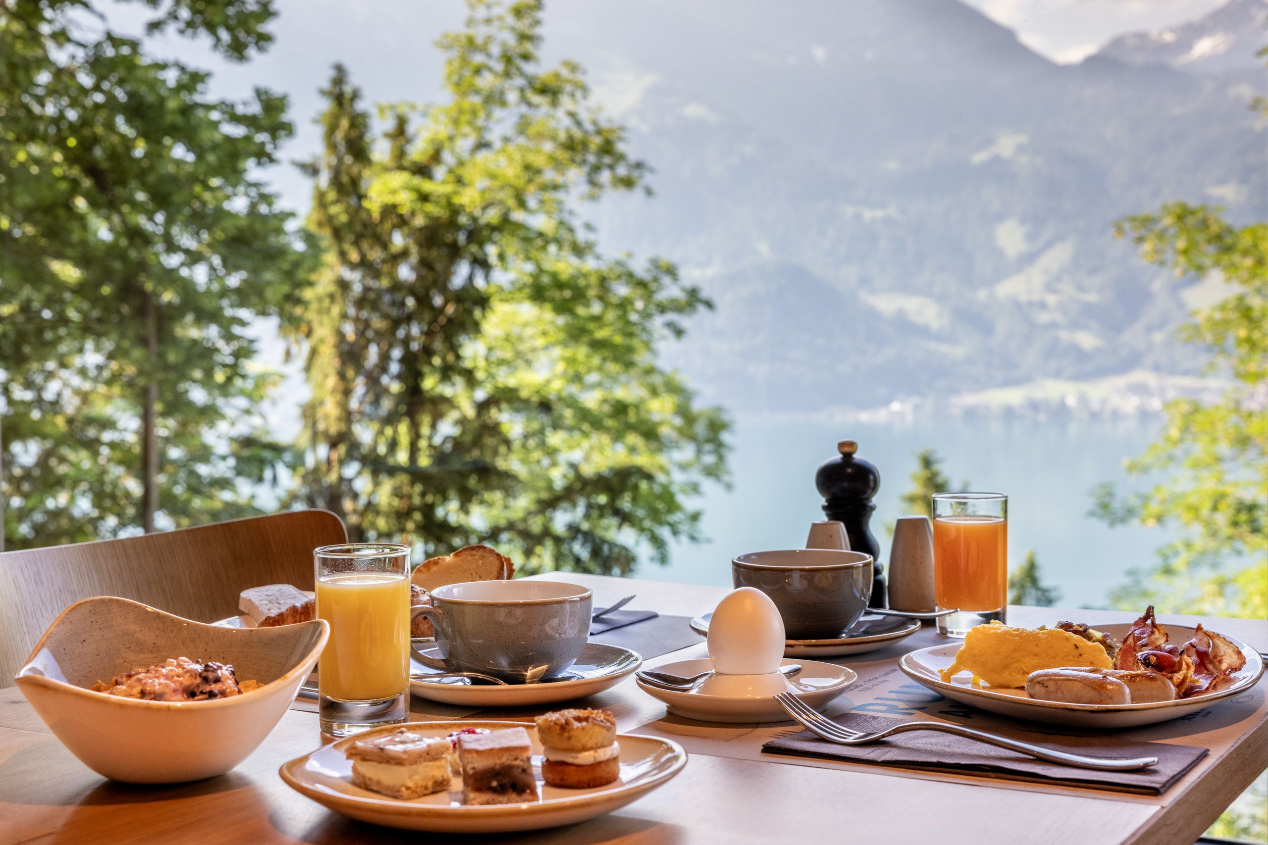 Brunch mit erlebnisreicher Aussicht auf die Berge und den See im Hintergrund, ideal für einen entspannten Morgen.