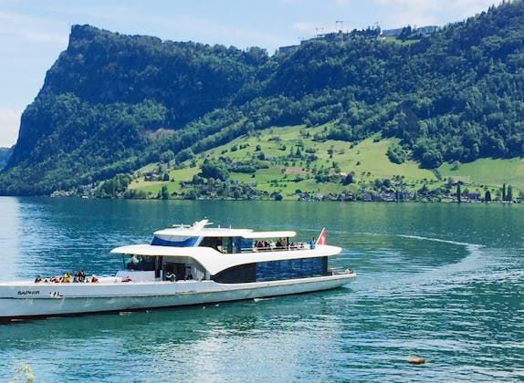 Saphir Yacht auf dem Vierwaldstättersee mit Blick auf die Berge und grüne Landschaft.