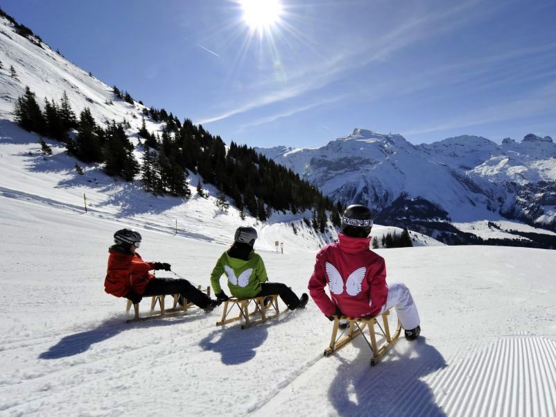 Slittino a Brunni Engelberg: I bambini si divertono con la neve e le montagne in inverno.
