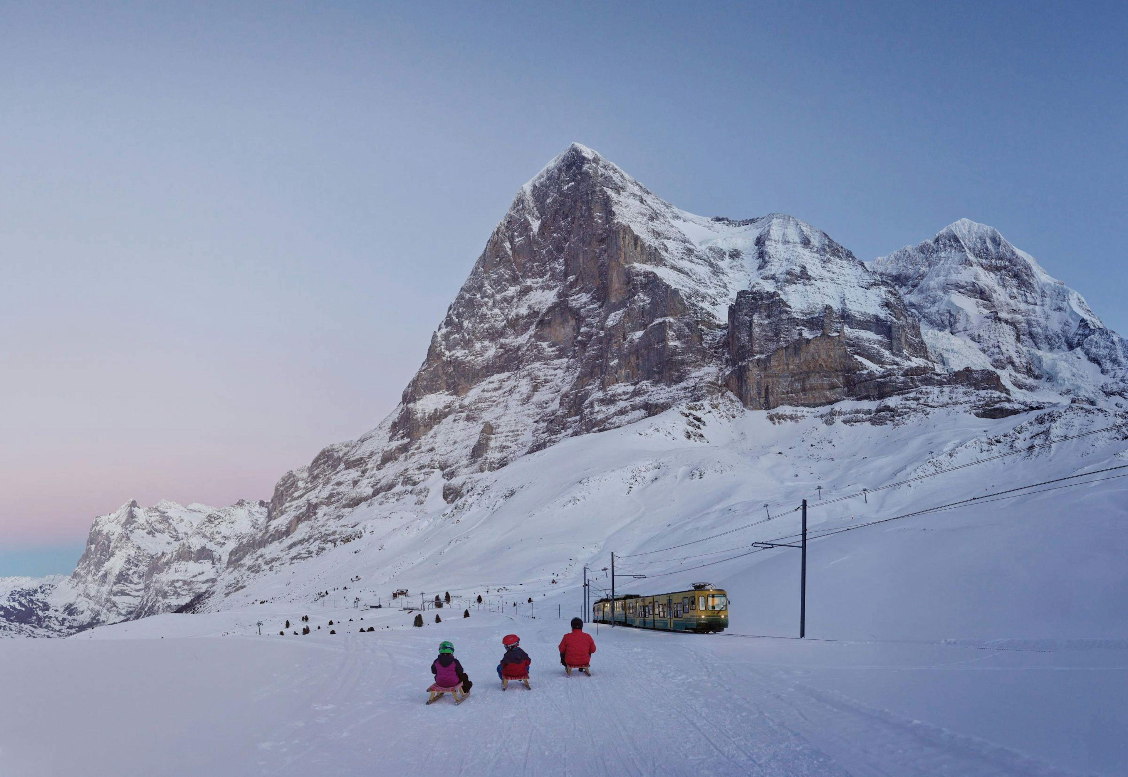 Eiger Run Schlitteln in der Jungfrauregion mit Kindern und Bergen im Winter.