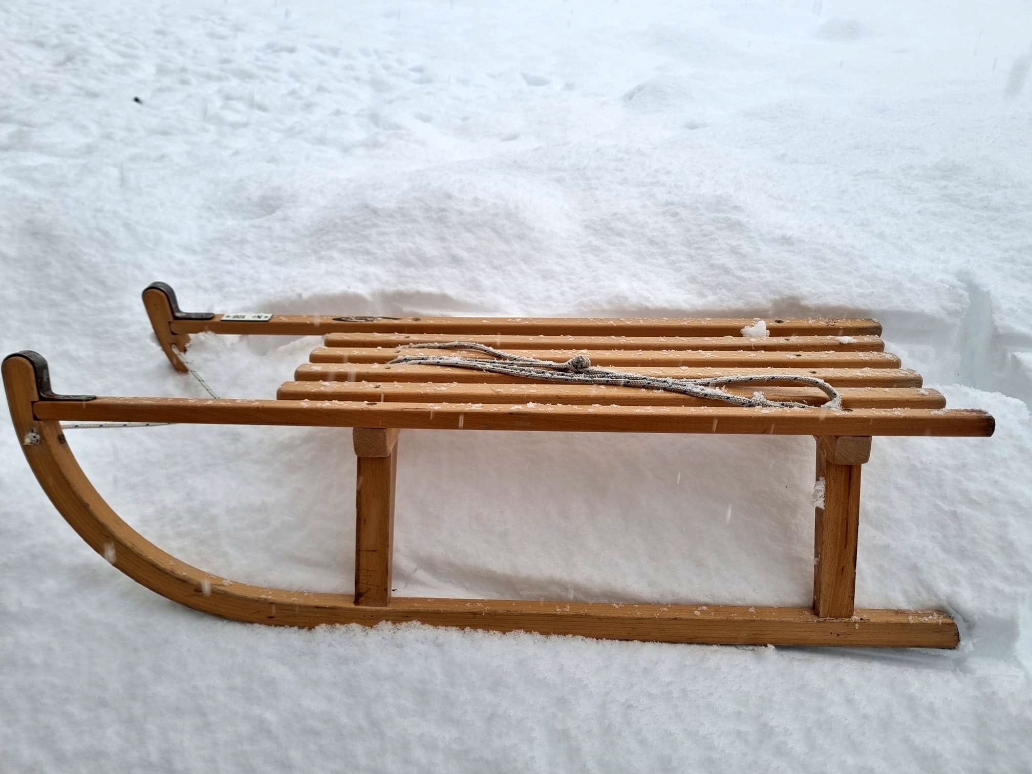 Давосская Зимняя Грильдевальдская скамейка лежит в снегу, окружена зимним пейзажем.