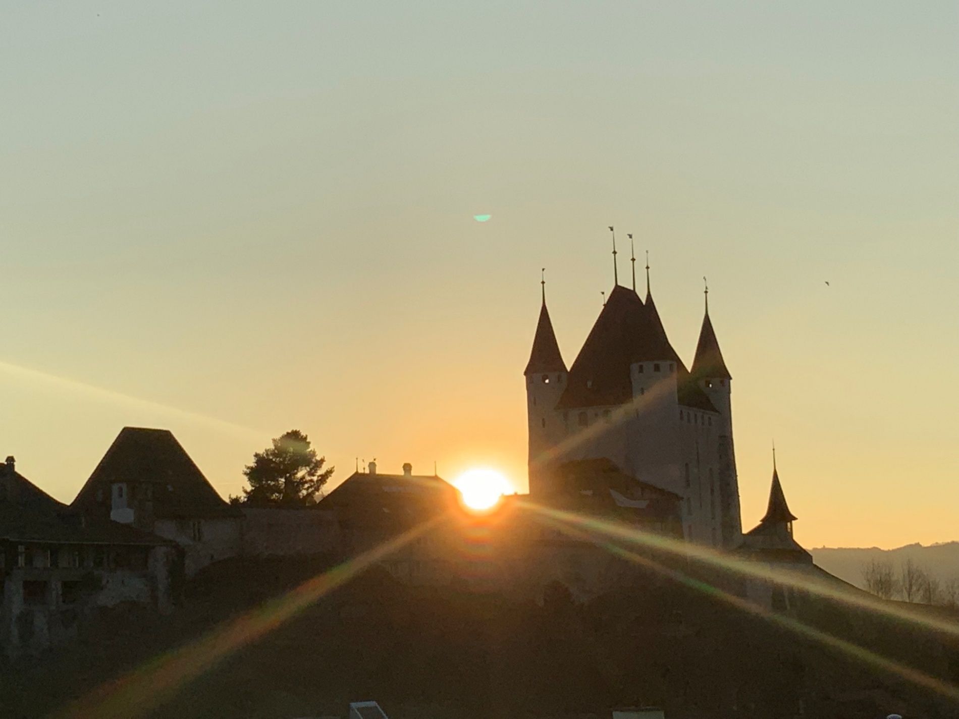 Κάστρο Θουν: εντυπωσιακή γραμμή απέναντι στον ήλιο που δύει, περικλεισμένη από βουνά και φύση.