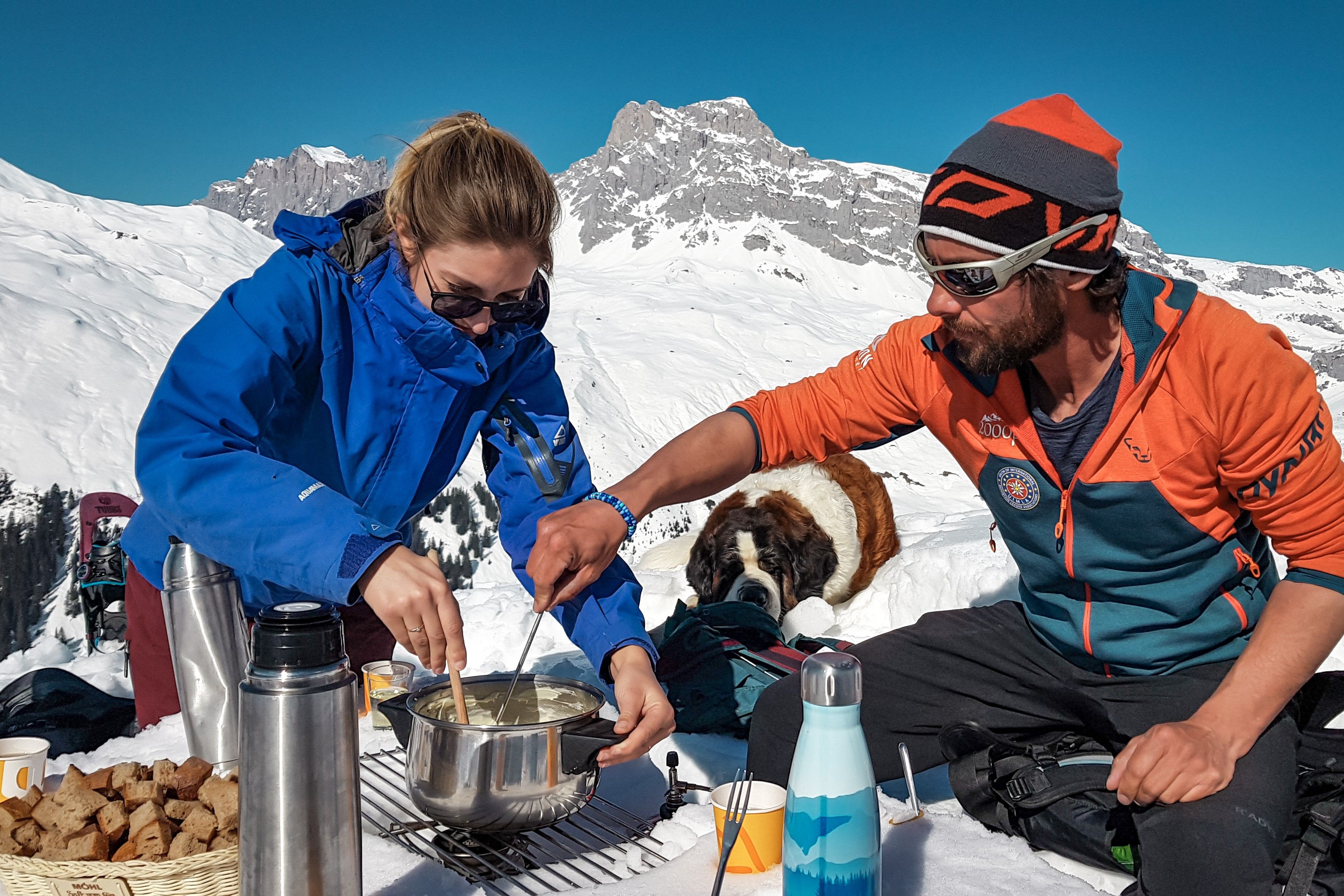 Randonnée en raquettes au sommet avec fondue à St. Antönien, randonneurs joyeux, préparation de la fondue