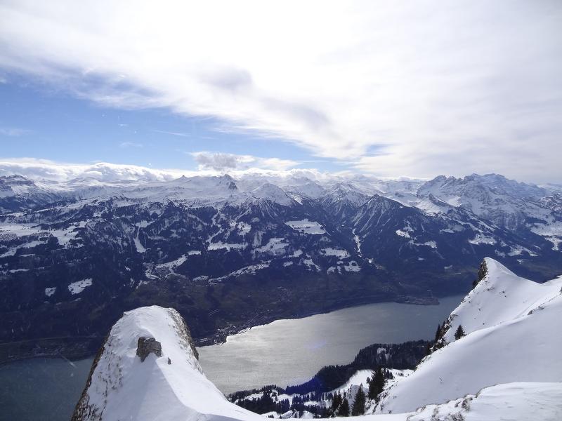 Excursión con raquetas de nieve en el valle de Frümsel con vistas a las montañas nevadas y al lago brillante.
