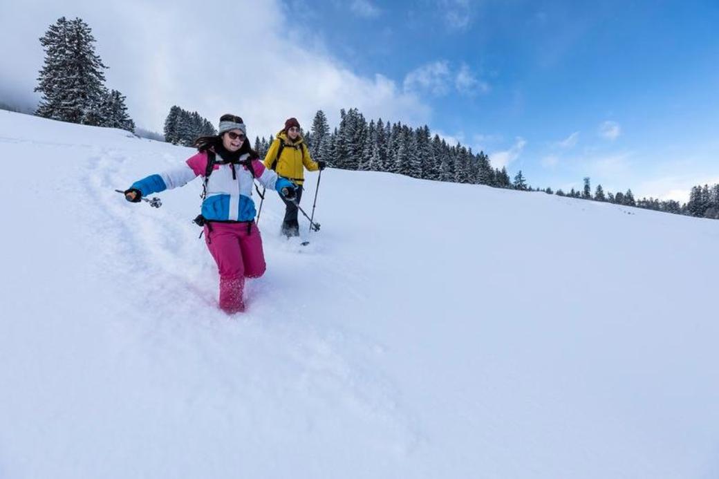 Snowshoe hiking in Schönhalden with friends in deep snow, perfect for adventure and nature lovers.