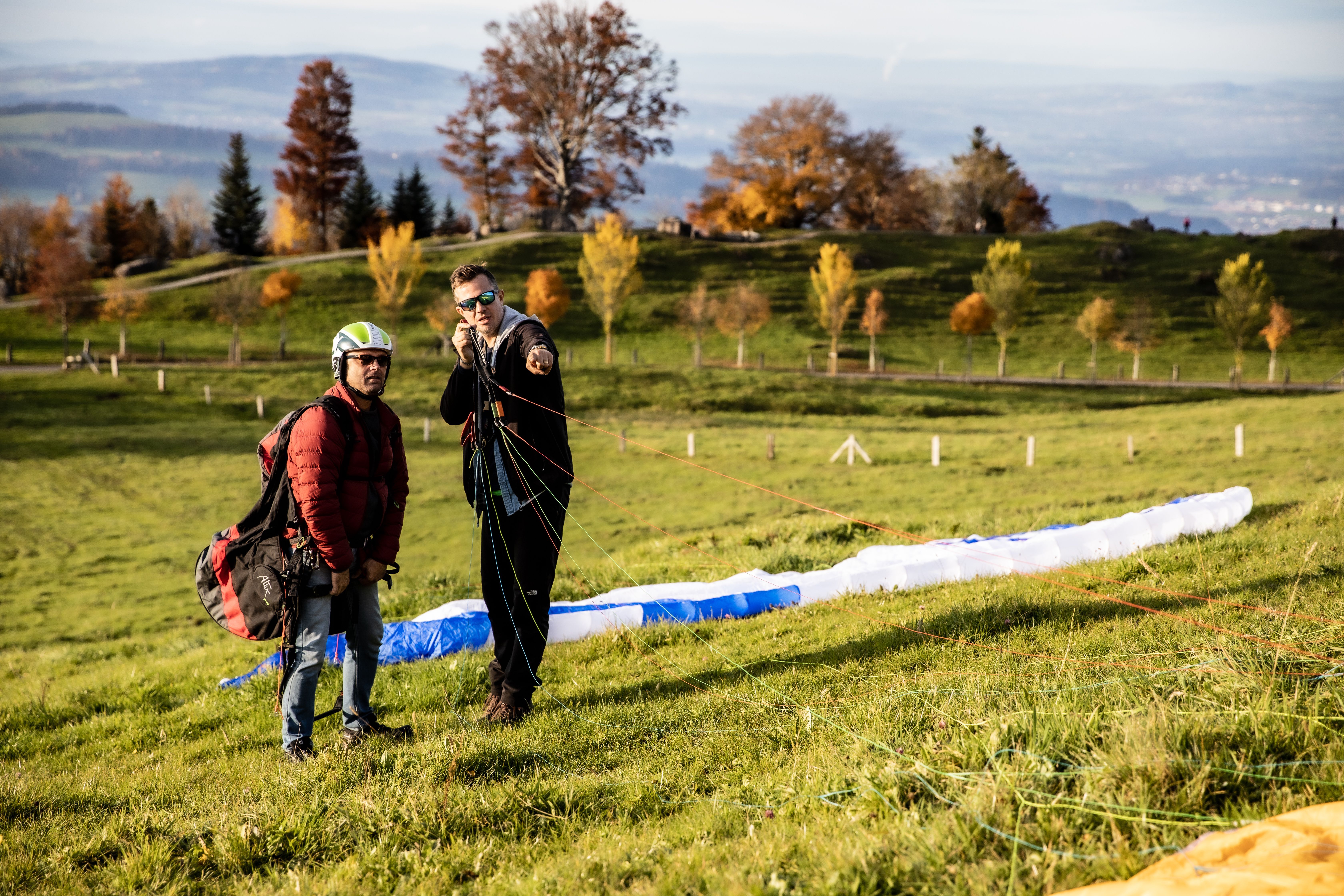 Paragliding proefdag in Zürich, deelnemers met uitrusting op een weide.