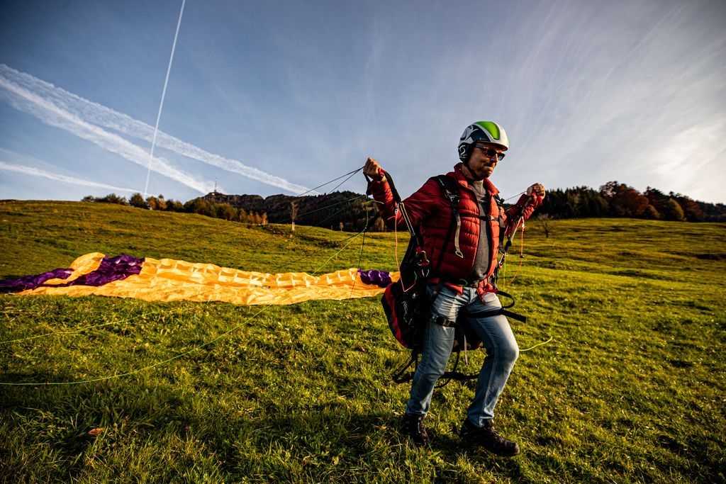 Paragliden introductiedag: Deelnemer bereidt zich voor op de vlucht, weide in Zürich.