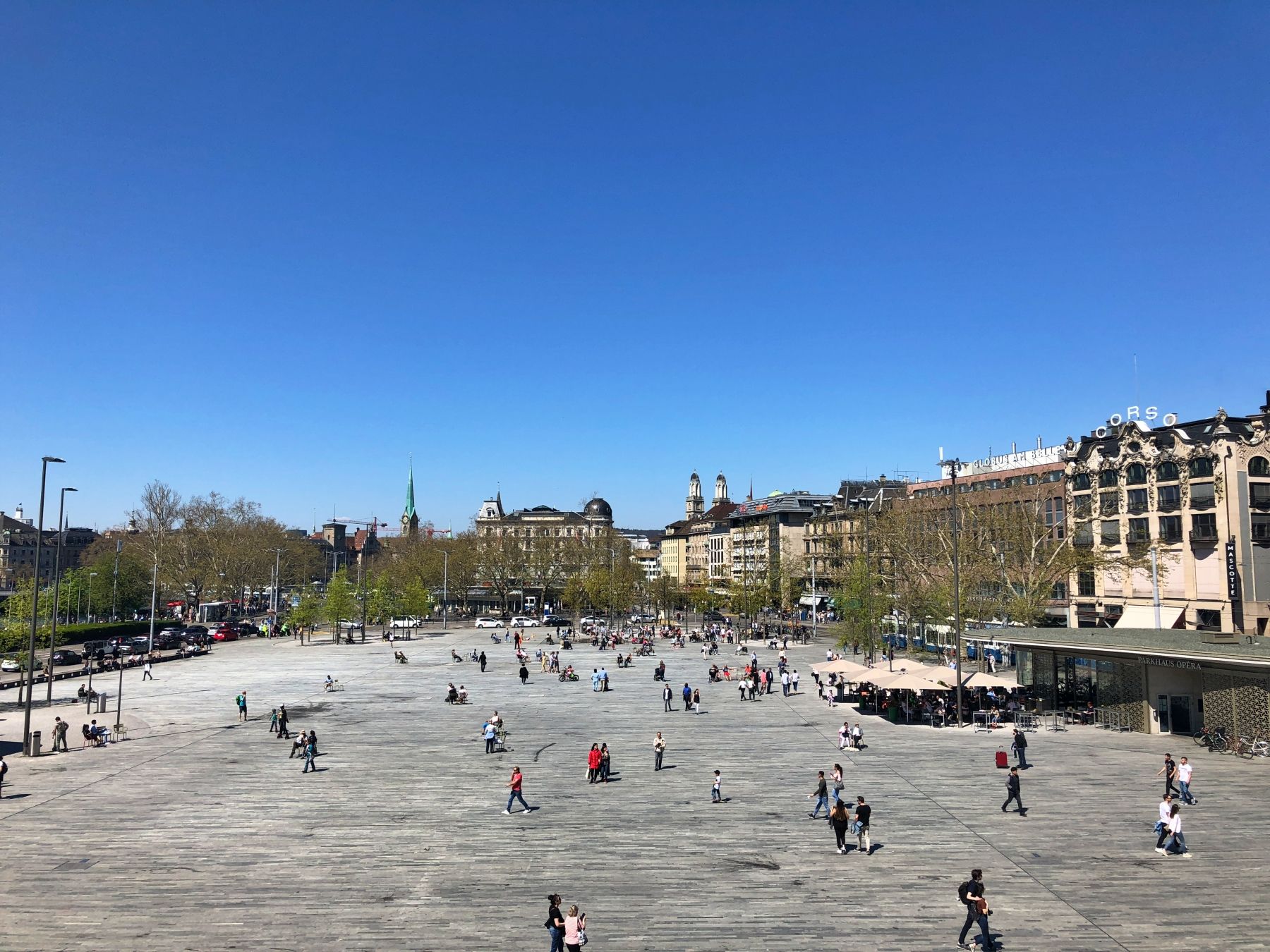 Sechseleutenplatz Zürich mit Besuchern, Sonnenschein und klaren Himmel.