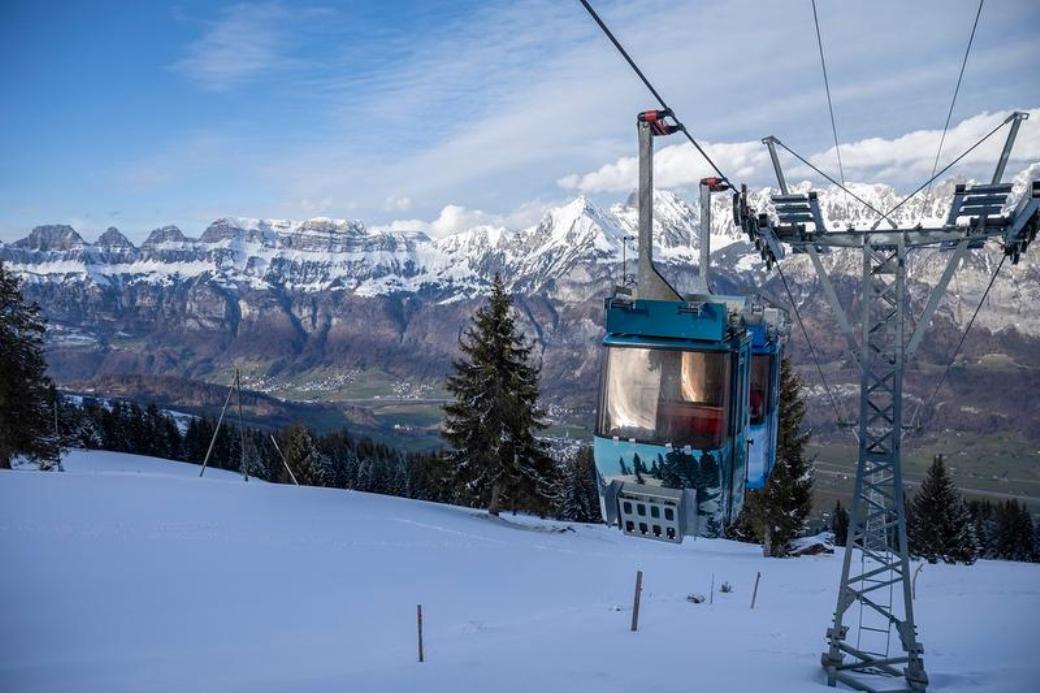 Schönhalden cable car with a view of the snow-covered mountains in nature.