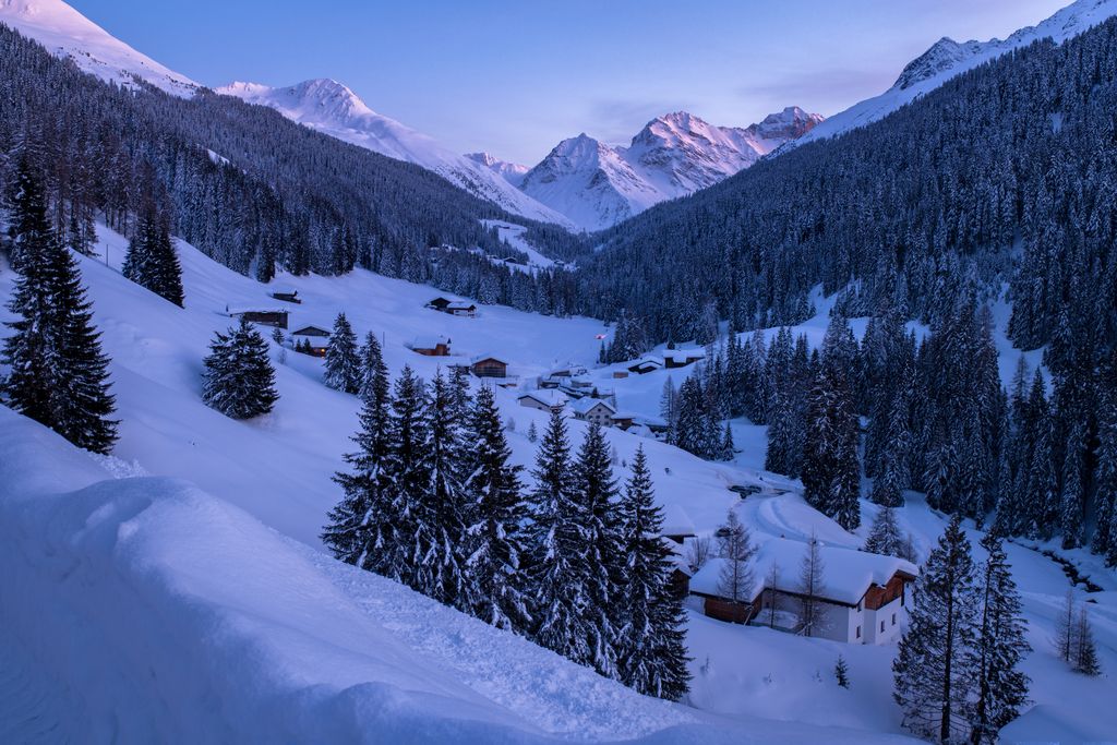 Night skiing course in Davos with snowy mountains and villages.