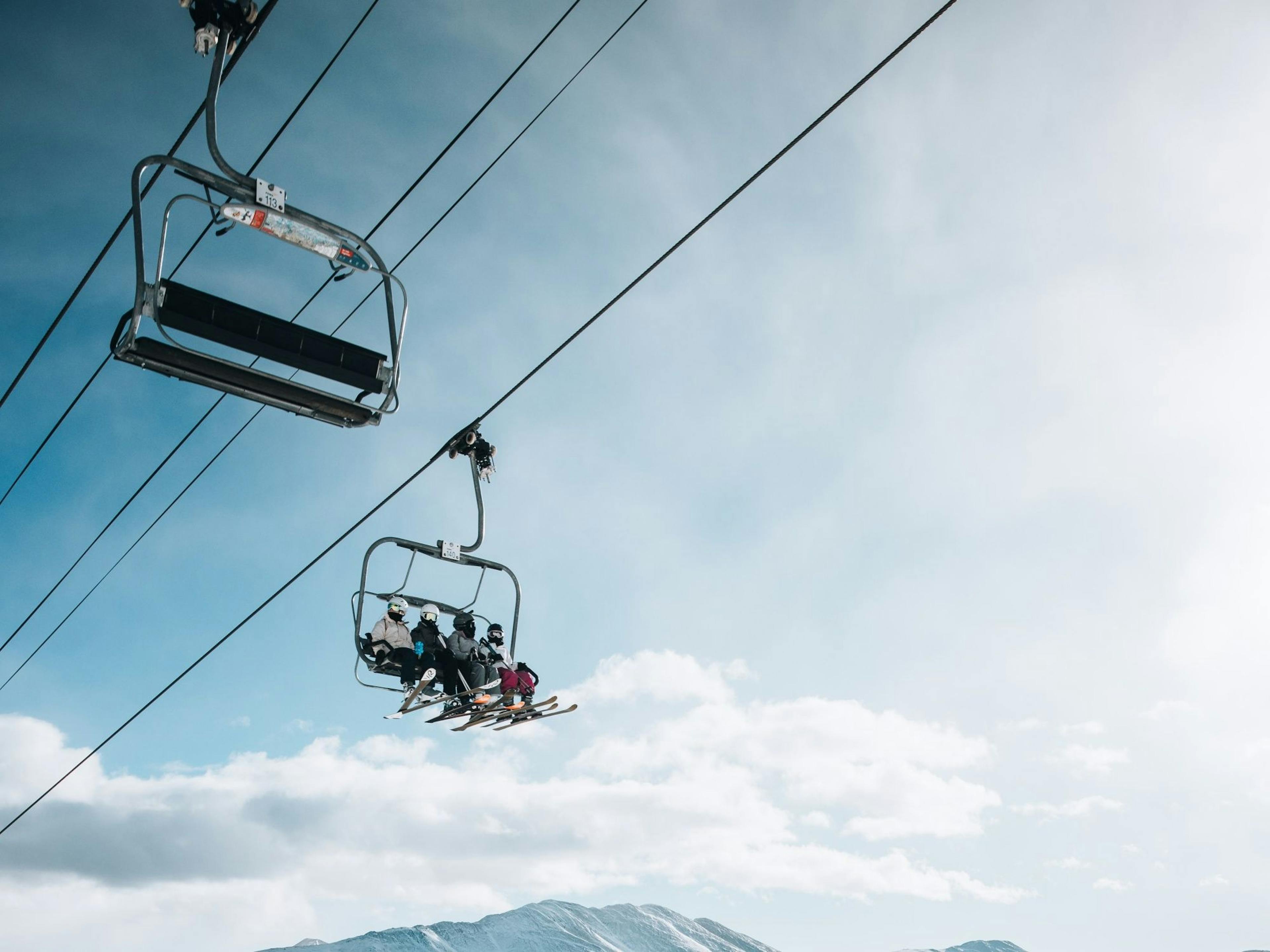 Rent skis in Grindelwald: Chairlift with impressive mountain panorama in winter.