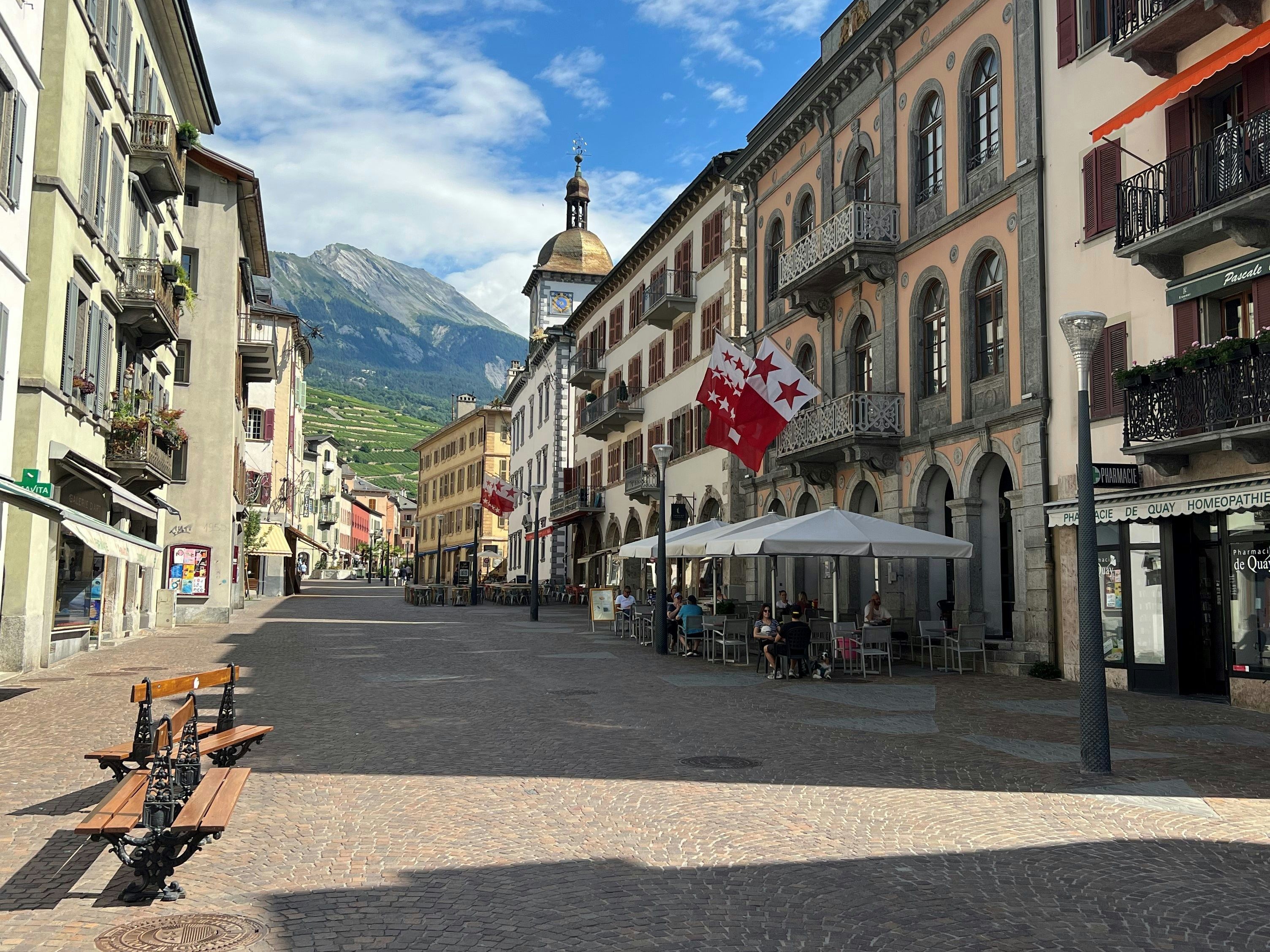 Dataran Bandar dengan bangunan bersejarah dan gunung di latar belakang, sesuai untuk budaya dan rekreasi.