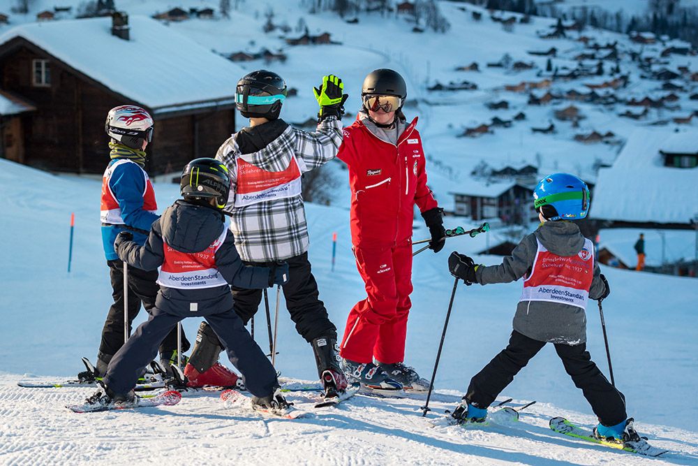 Gruppenunterricht Ski Kinder: Eine Gruppe von Kindern beim Skifahren in den Bergen, ideale Winteraktivität.