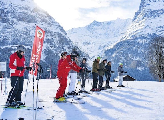التزلج في غريندلوالد في جو صافٍ، مدرب تزلج مع مجموعة