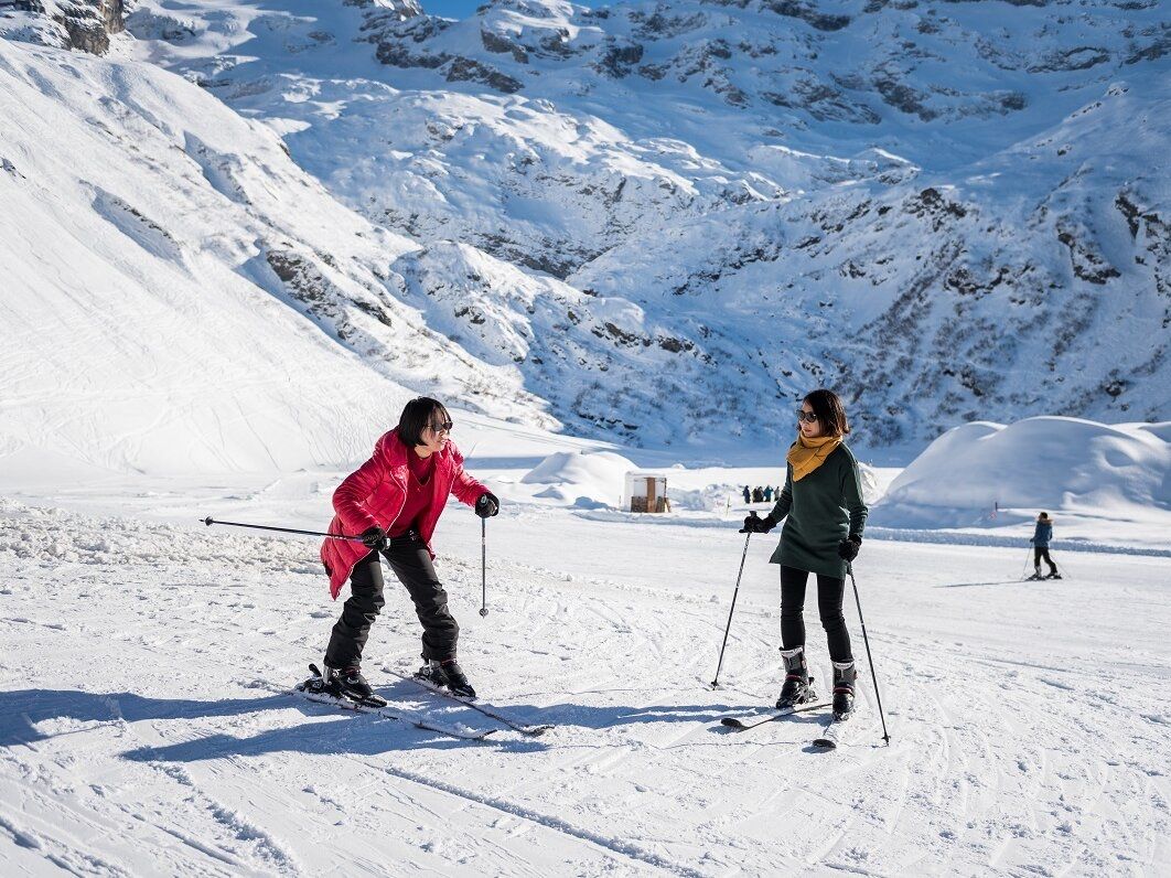 Ski sur le Titlis pour débutants. Montagnes enneigées et skieurs en vêtements chauds.