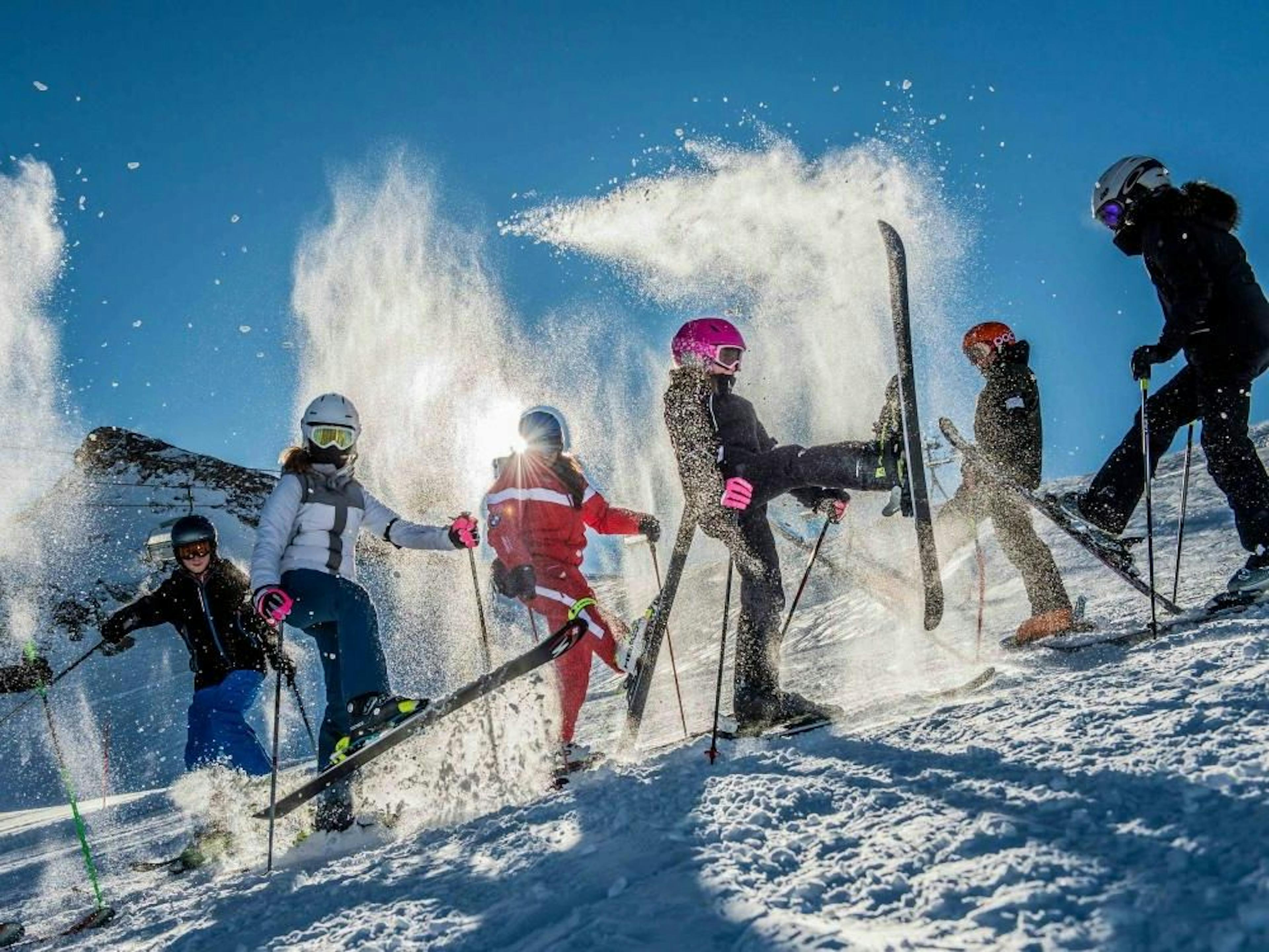 Fortgeschrittene Kinder in der Skischule Zermatt üben das Skifahren im Schnee bei sonnigem Wetter.