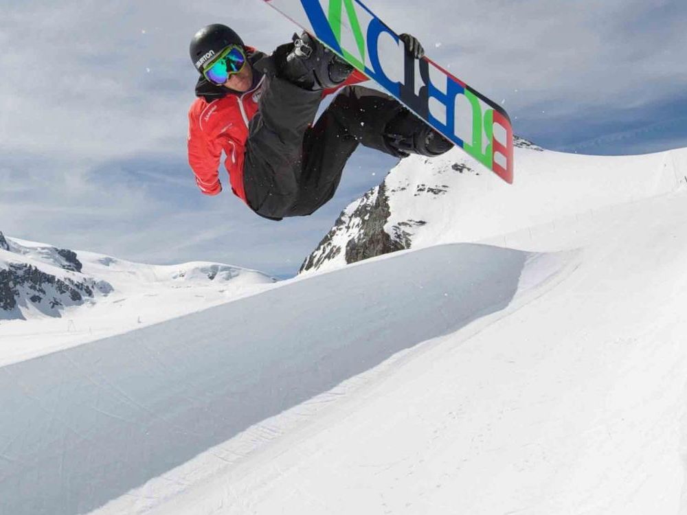 Freestyle Snowboard privatundervisning i Zermatt, hvor deltageren springer over et forhindring i sneen.